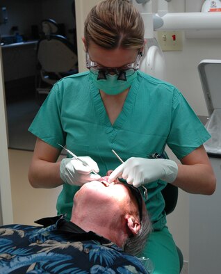 Dr. (Capt.) Michelle Heath, a dentist with the 341st Medical Group, performs a dental exam on Russell Jacques April 25. Dental clinic staff members served 24 retirees April 24 and 25. (U.S. Air Force photo/Valerie Mullett)