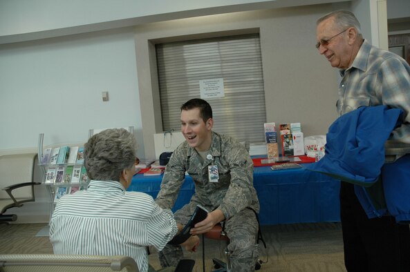 Airman Zachary Freeman, a member of the 341st Medical Operations Squadron Aerospace Medical Services team, shares a lighter moment with Vivian Peterson prior to checking her blood pressure April 24. Free blood pressure screenings were one of the many services offered to retirees during the annual Retiree Appreciation Weekend April 24-25. Vivian's husband, Scott, looks on. (U.S. Air Force photo/Valerie Mullett)
