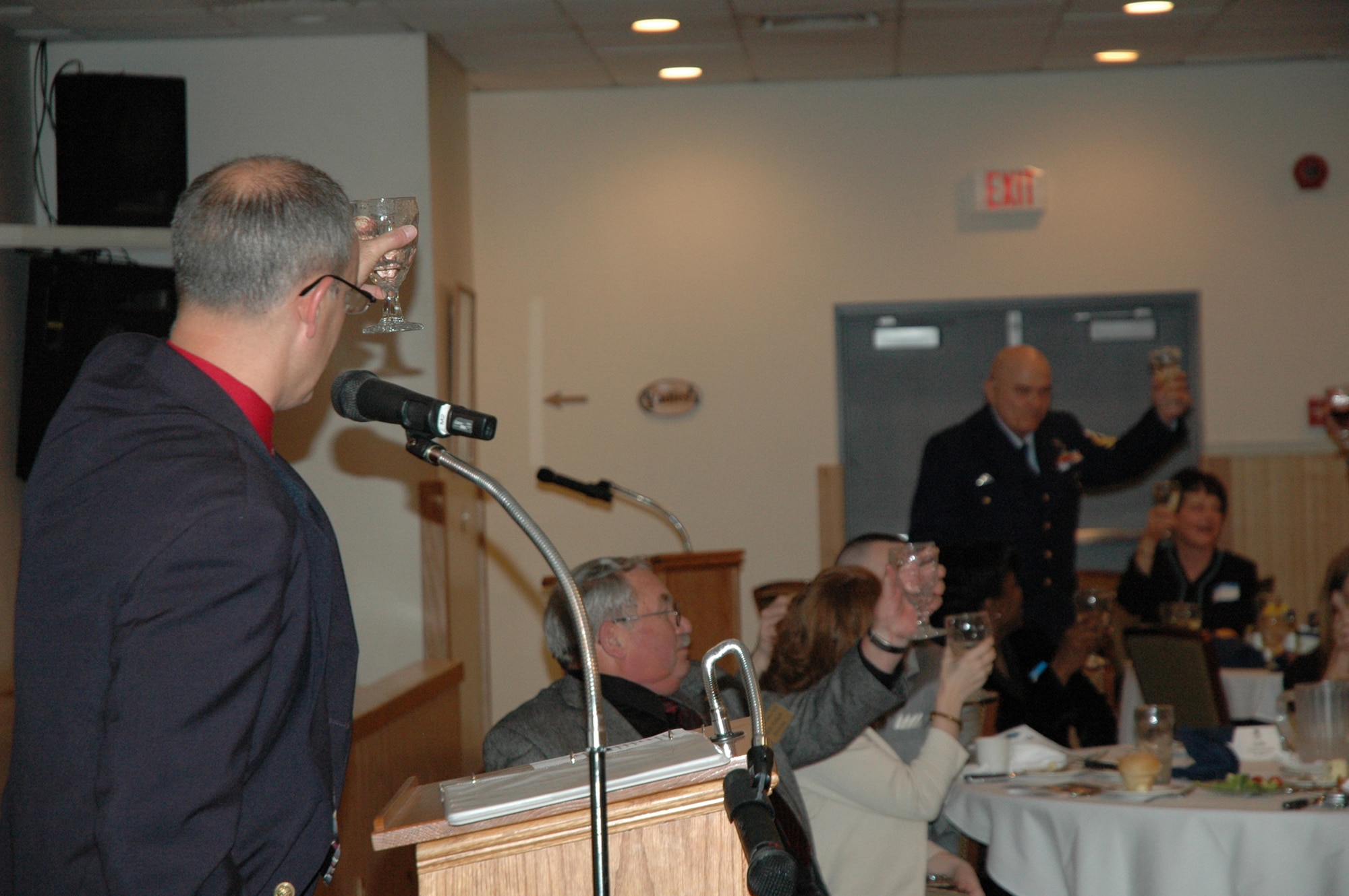 Col. Michael Fortney (left), 341st Missile Wing commander, toasts the members of each branch of the military before closing his address to the retirees April 25.  (U.S. Air Force photo/Valerie Mullett)