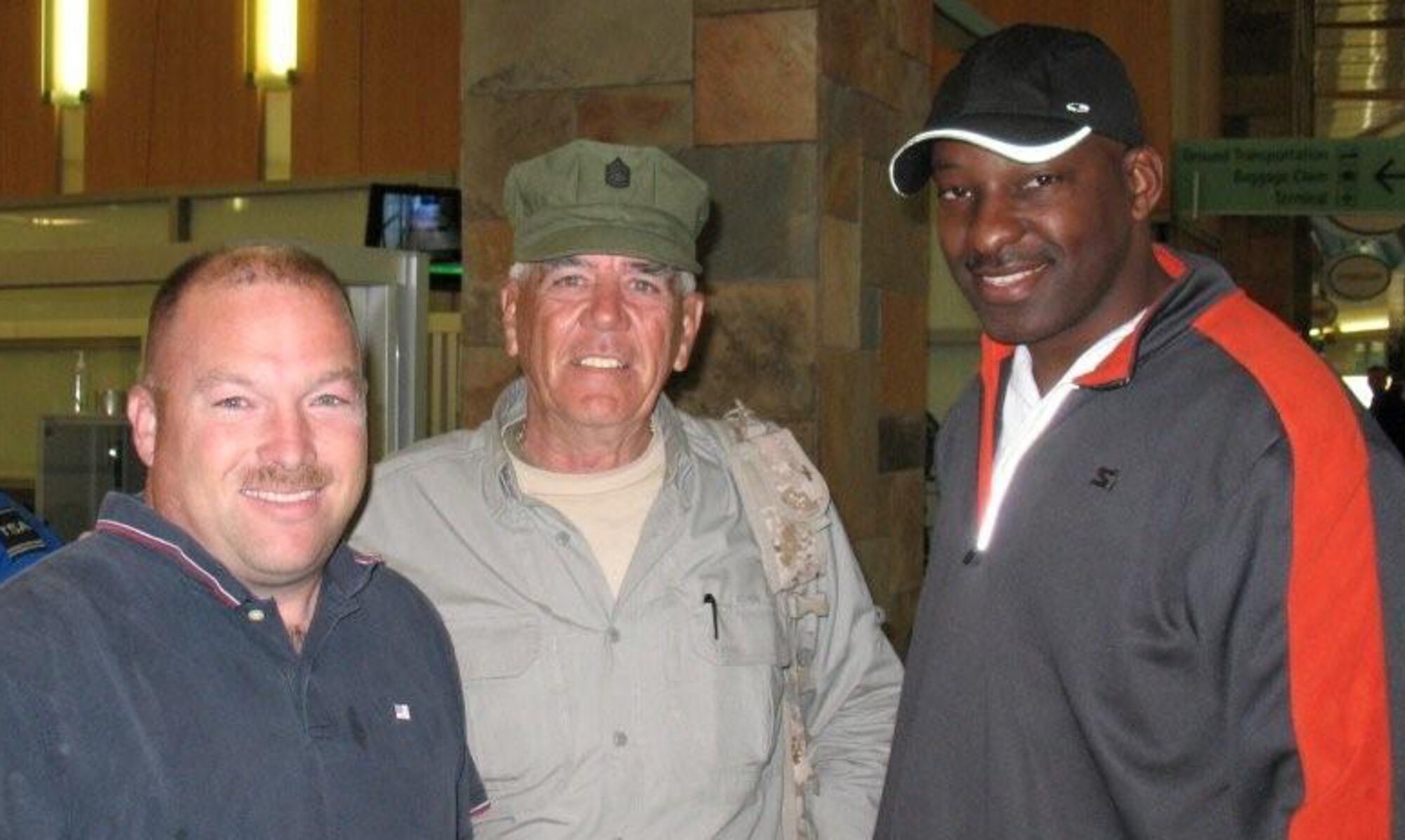 SEYMOUR JOHNSON AIR FORCE BASE, N.C. -- Master Sgt. Chris Scher (left) and Tech. Sgt. Leroy Evans (right) meet actor and former Marine E. Lee Ermey in the Oklahoma City Airport coming home from a KC-135 Product Improvement Working Group conference. Mr. Ermey is probably best known for his role as Gunny Hartman in the movie Full Metal Jacket.
