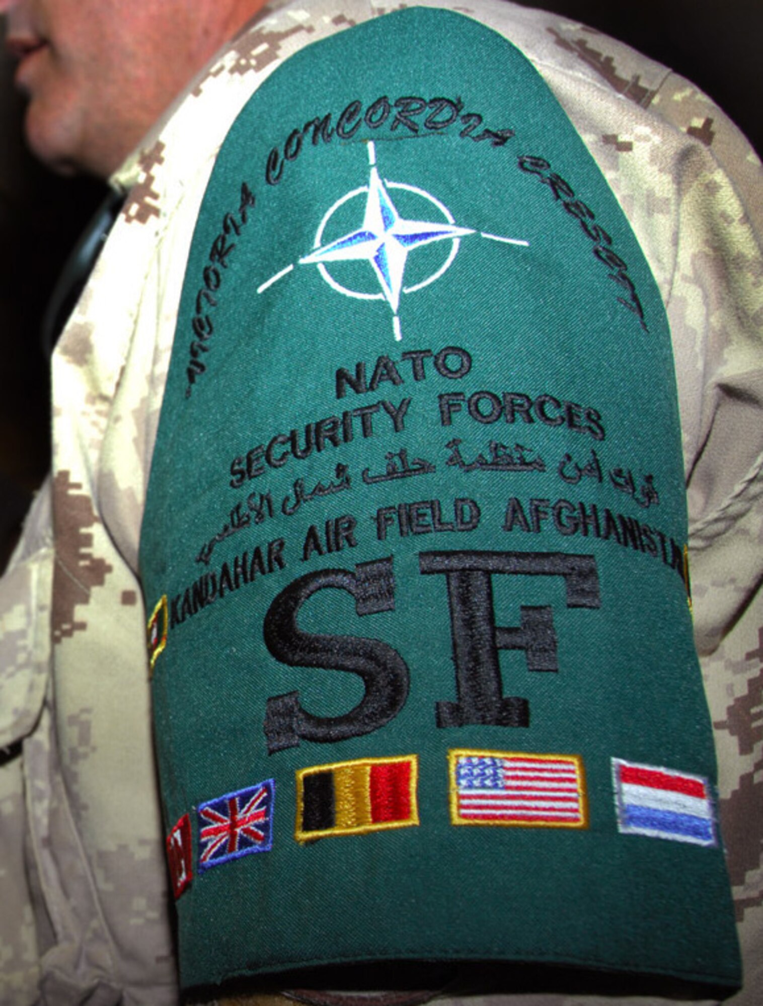 Military members of NATO security forces performed a guard mount May 1 to kickoff the concept of operations for a more secure, aggressive flight line security program here.  Air Commodore Andrew Fryer, Commander of Kandahar Airfield, spoke to security forces of six different nations represented within NATO, including the 451st Air Expeditionary Group. Members of the newly consolidated NATO flight line security program now wear a new brassard with all the nations' flags and the motto, "Victoria Concordia Crescit," or "victory through unity."
