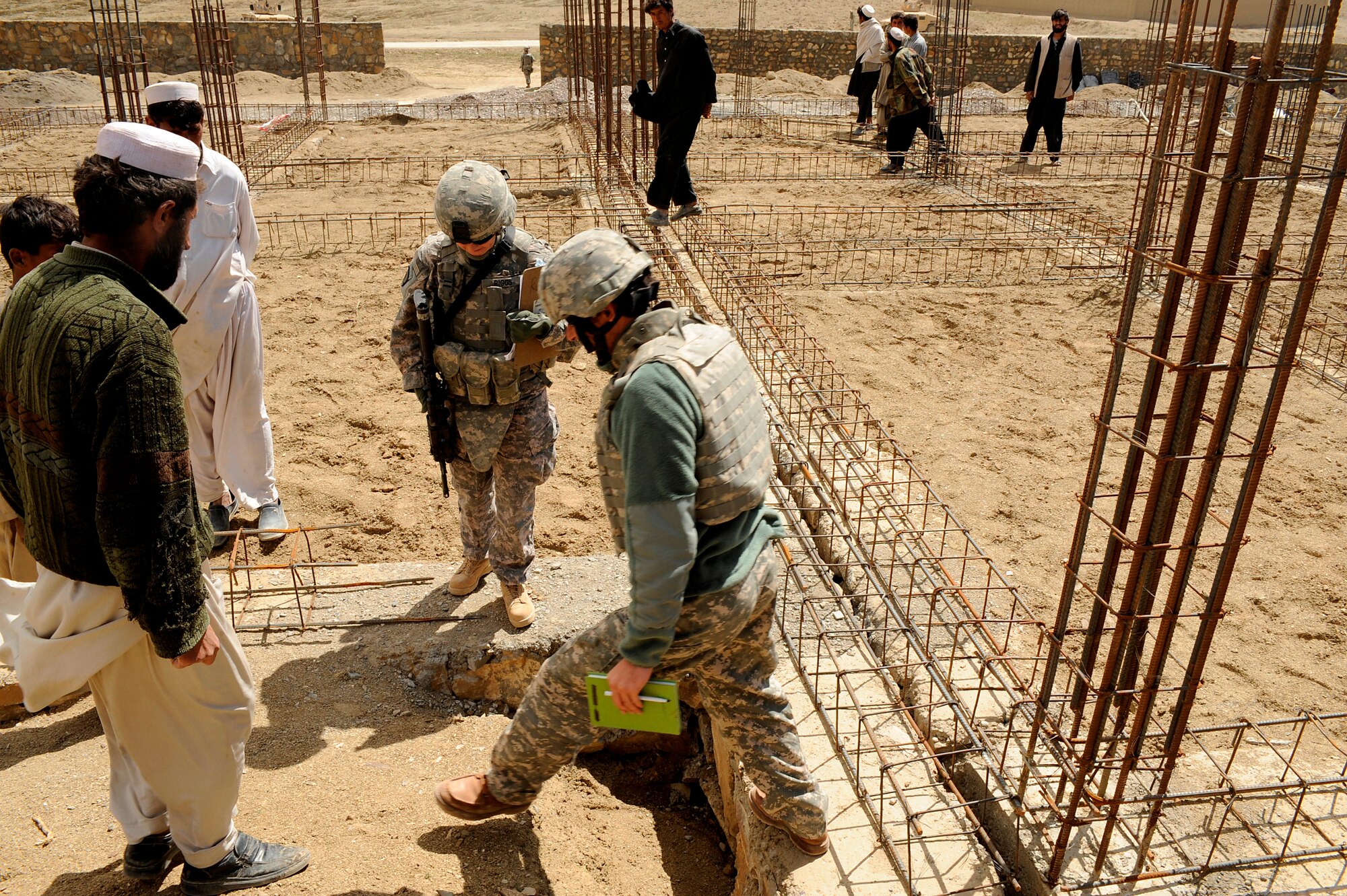 U.S. Air Force Maj. Kimberly Riggs, the engineer officer in charge of the Paktya Provincial Reconstruction Team, works with her interpreter and local contractors to assess the initial construction work  for the Osman Khel School, Gardez City, Afghanistan, April 13, 2009. (U.S. Air Force photo by Staff Sgt. Shawn Weismiller)