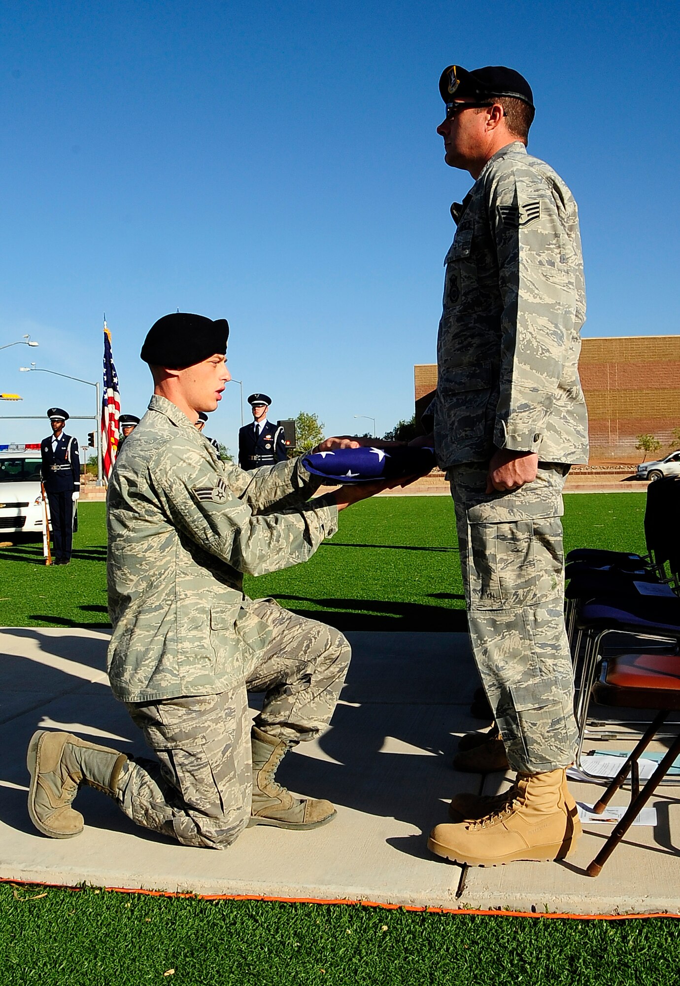 Senior Airman Evan Greene, a 49th Security Forces Squadron patrolman, presents the American Flag to Staff Sgt. Kevin Williams, K-9 handler/patrolman, during a memorial service May 1. The service was held to honor Uro, a Military Working Dog, who died at Holloman Air Force Base, N.M., April 24 (U.S. Air Force photo/Tech Sgt Chris Flahive)