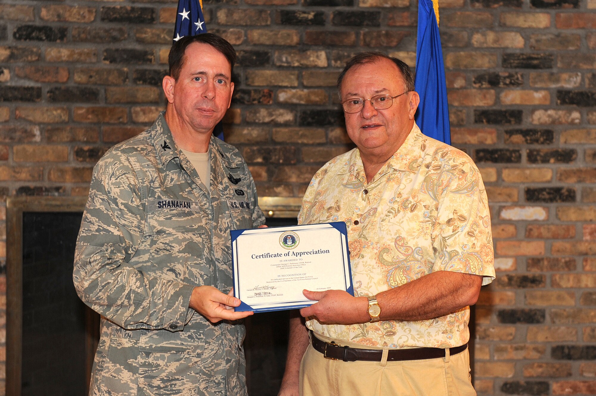 OFFUTT AIR FORCE BASE, Neb. - Col. John N.T. Shanahan, 55th Wing commander and retired commander George Parkerson, a volunteer with the Retiree Activities Office, pose for a picture after Commander Parkerson received the Retiree Activities Office Volunteer of the Year award during the Volunteer Appreciation Reception at the Community Activity Center here April 29. U.S. Air Force Photo by Josh Plueger
