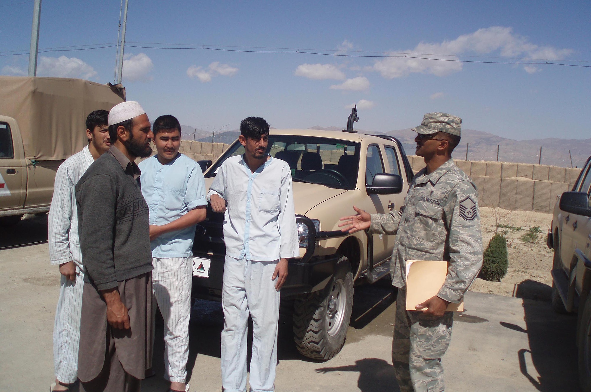 Master Sgt. Dewane Brown practices the Dari language and talks with patients outside of a hospital located near the Pakistan border in Afghanistan. In addition to his medical logistics duties, Sergeant Brown volunteers his off-duty time to teach English to the Afghan National Army three times a week.