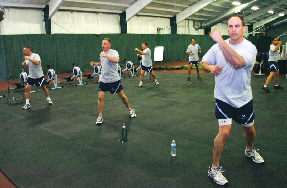 William Preston, far right, 99th Airlift Squadron, accompanies his squadron members in performing P90X Kenpo X exercises in the Tactical Fitness room at the the West Fitness Center Tuesday. (U.S. Air Force photo/ Bobby Jones)