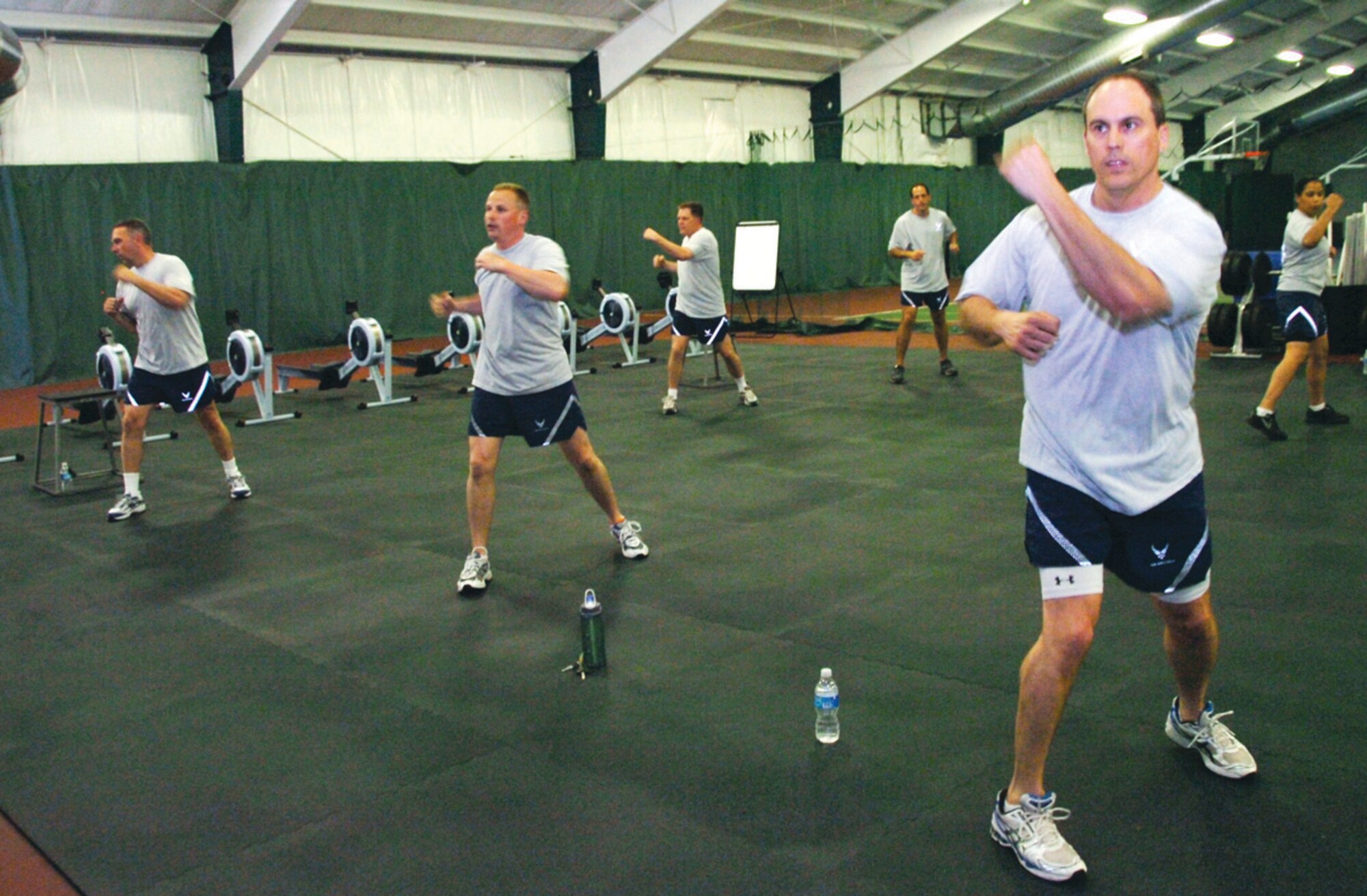 William Preston, far right, 99th Airlift Squadron, accompanies his squadron members in performing P90X Kenpo X exercises in the Tactical Fitness room at the the West Fitness Center Tuesday. (U.S. Air Force photo/ Bobby Jones)