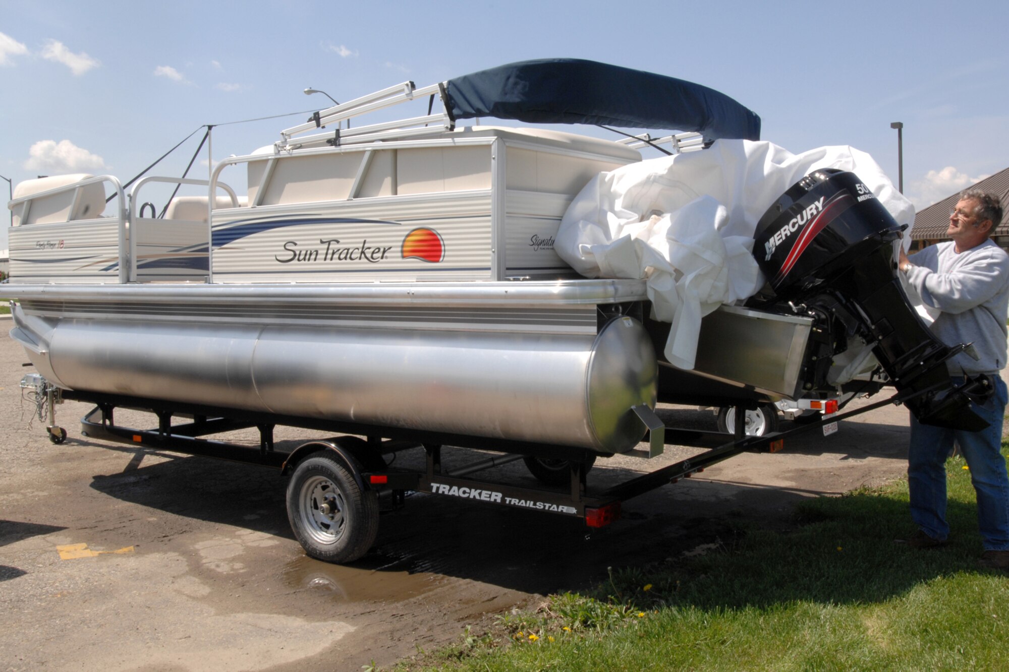 GRISSOM AIR RESERVE BASE, Ind., -- Carl Wade, a civilian outdoor recreation specialist with the 434th Services Flight, uncovers a new pontoon that was placed into service just in time for spring. The pontoon was purchased in an effort to encourage outdoor recreational activities amongst Airmen. (U.S. Air Force photo/ Staff Sgt. Ben Mota)