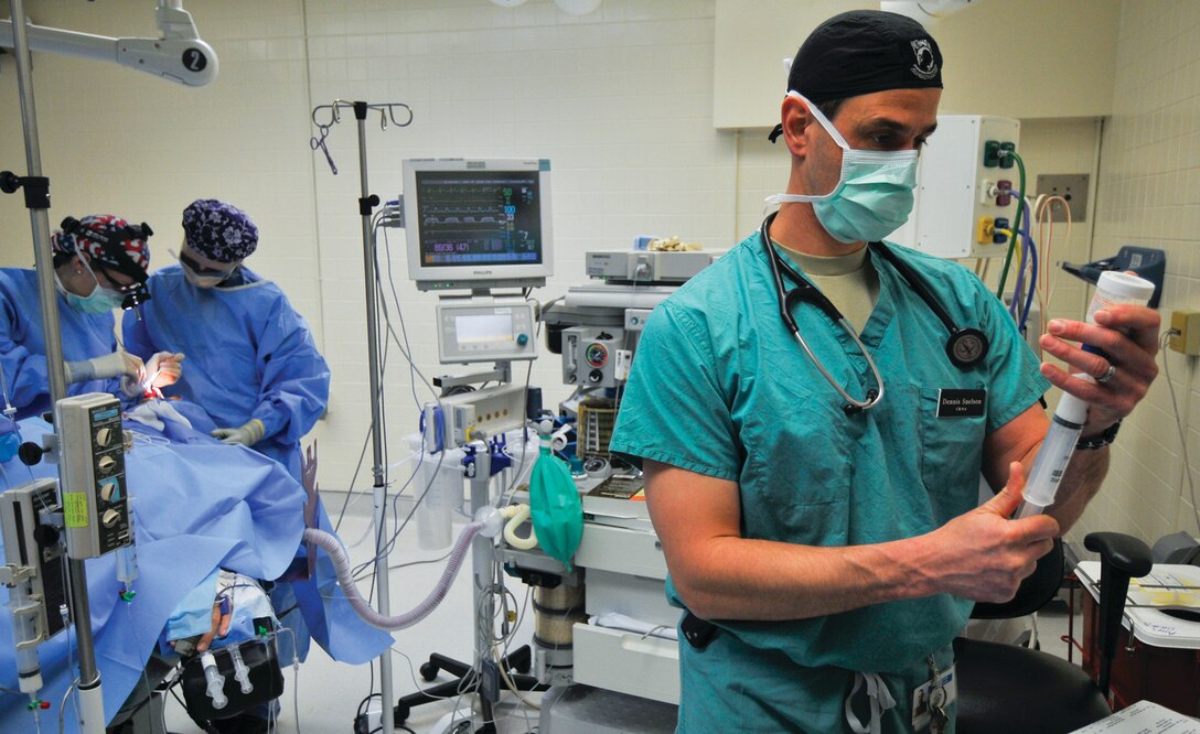 Captain Dennis Snelson, 779th Surgical Operations Squadron certified registered nurse anesthetist, right, assists with a septorhinoplasty and inferior turbinate reduction at MGMC March 20. This procedure will help the patient breathe better through his nose and improve his quality of sleep. (U.S. Air Force photo/ Tech. Sgt Suzanne M. Day)