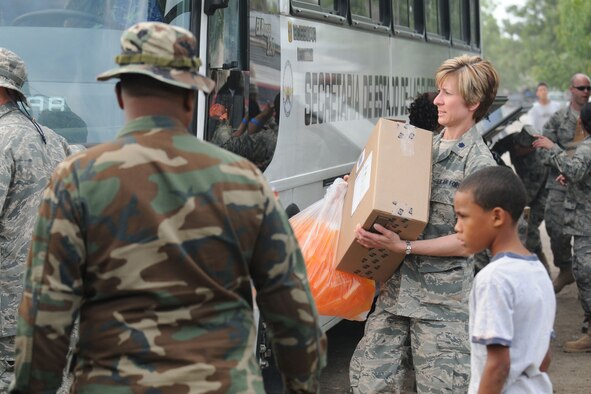 AZUA, Dominican Republic — U.S. Air Force Reserve Lt. Col. Carolyn Katrinchak works alongside Dominican Army troops, April 27, 2009 to unload medical supplies from a bus here. Col. Katrinchak, assigned to the 910th Medical Squadron, is participating in MEDRETE (Medical Readiness Exercise) 2009 designed to provide local residents with much needed medical care. U.S. Air Force photo by Senior Airman Clinton Kline.