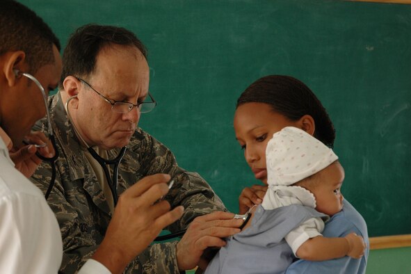 AZUA, Dominican Republic — U.S. Air Force Reservist Col. Larry Woods, assigned to the 910th Medical Squadron, examines a Dominican child in the Family Care section of Dominican Republic Medical Readiness Training Exercise (MEDRETE) 2009 here. Col. Woods is a member of a team of more than 30 Citizen Airman providing much needed medical care to more than 10,000 Dominican residents during this mission. The group left Youngstown Air Reserve Station, Ohio on April 25 and is scheduled to return on May 8. U.S. Air Force photo by Tech. Sgt. Dennis J. Kilker Jr.