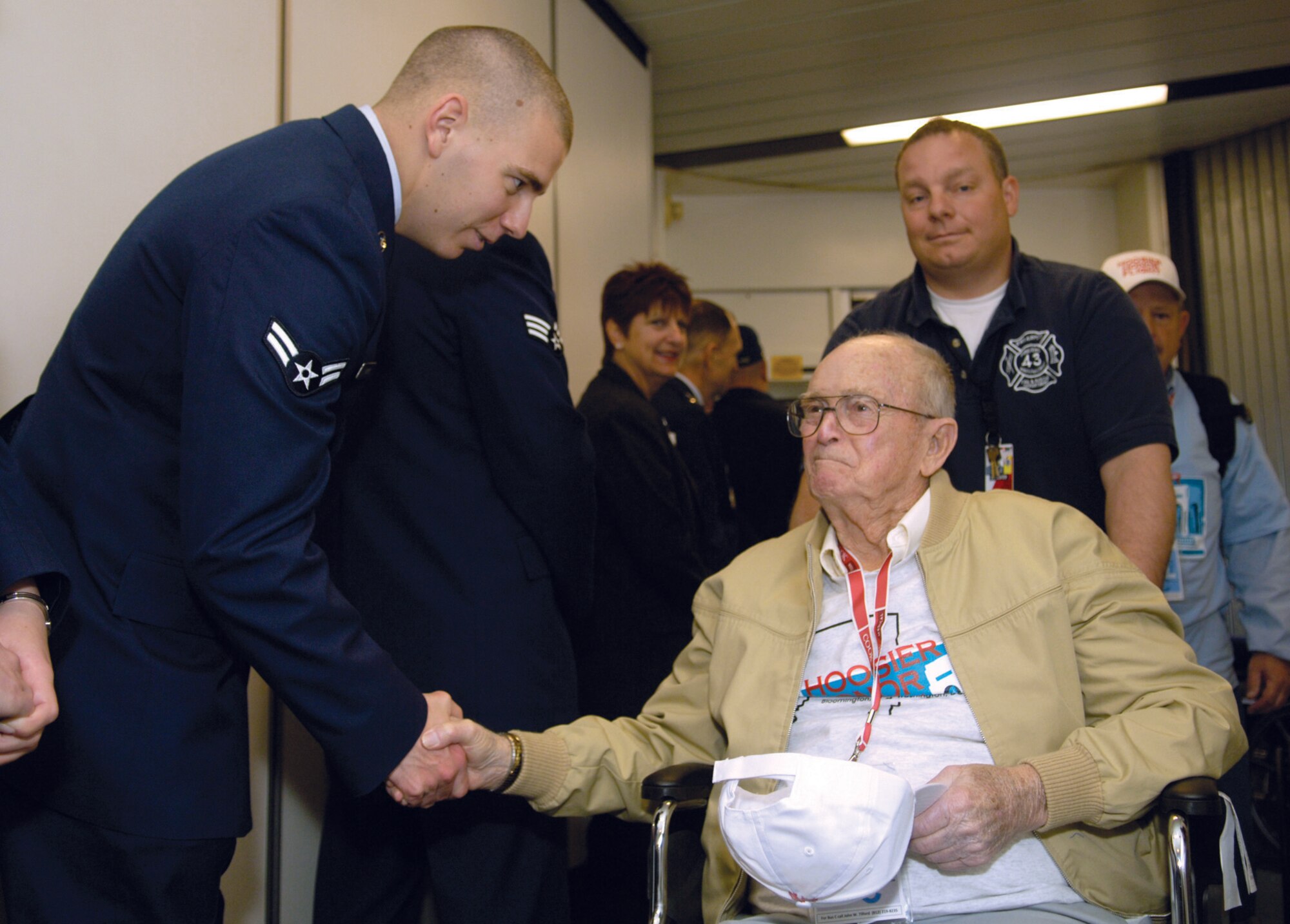 Airman 1st Class Thomas Parks, 779th Medical Operations Squadron aerospace medicine technician, greets Robert Jones, a World War II veteran, as he departs an aircraft at Baltimore Washington International Airport April 22. Several Andrews members welcomed and thanked arriving members of the Honor Flight program on the first leg of their D.C. tour. (U.S. Air Force photo/ Senior Airman Renae Kleckner)