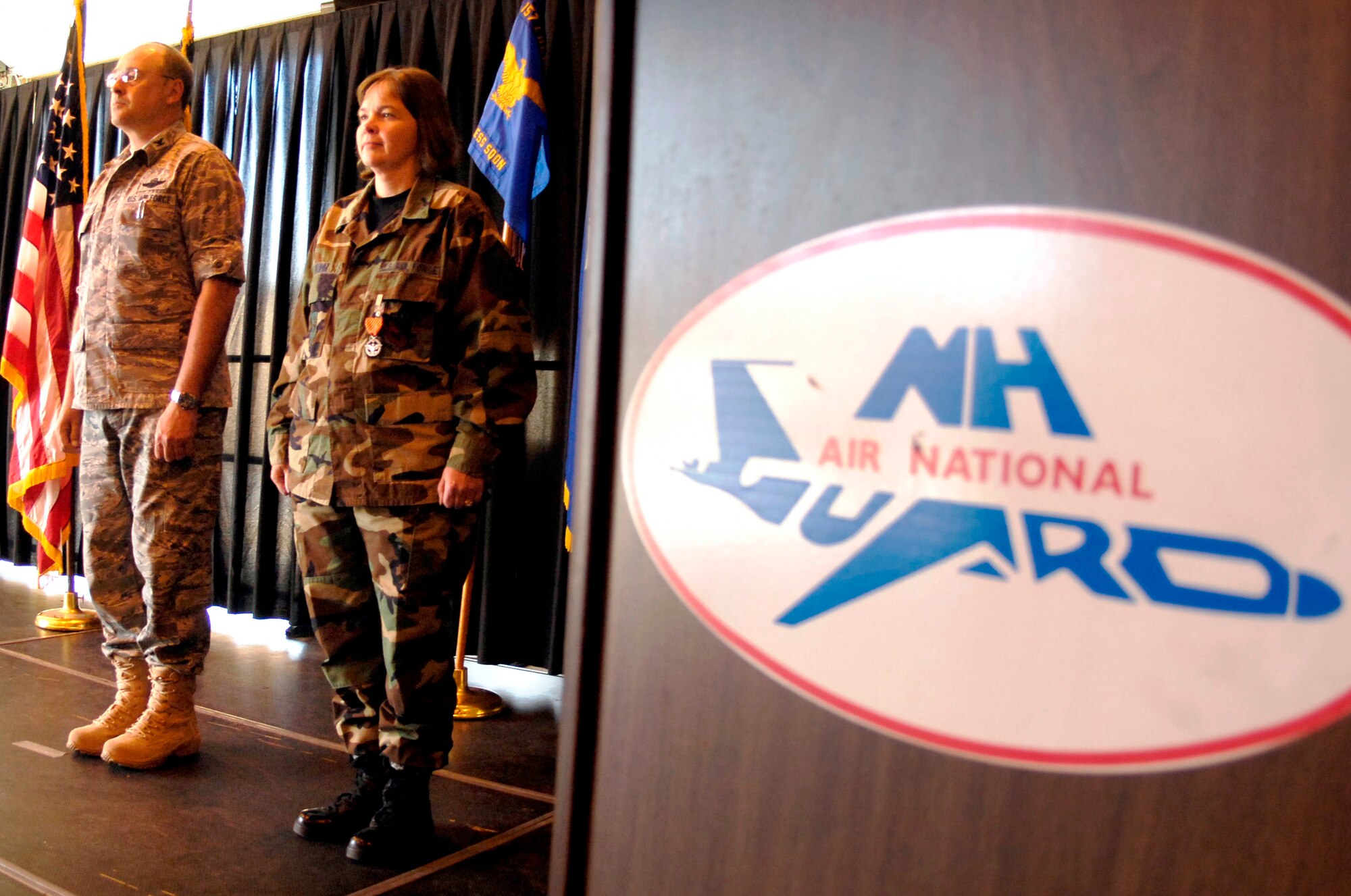 Master Sgt. Nancy Young, a member of the 157th Air Refueling Wing Logistics Readiness Squadron, stands at attention with Col. Richard Martell, Wing Commander, after being presented with the unit's first Combat Action Medal on May 2. (Photo by Tech. Sgt. Mark Wyatt, 157 ARW Public Affairs Multimedia Center)