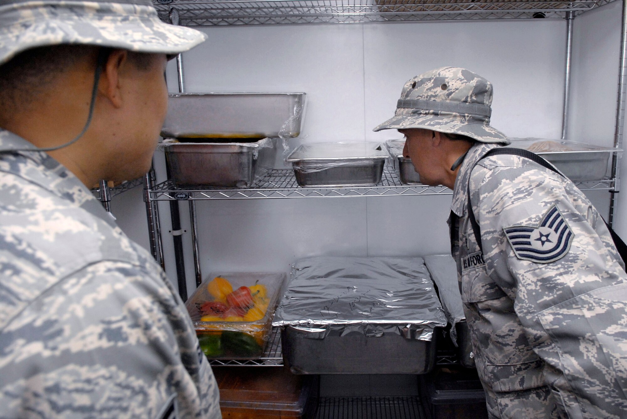 Staff Sgt. Rommel Hernandez and Tech. Sgt. Duwayne Foster inspect food in cold storage at the Independence Dining Facility to ensure the food is properly refrigerated during their monthly dining facility inspection April 18 at an air base in Southwest Asia. The Public Health office inspects the dining facilities, checks personnel medical records, and provides medical intelligence for forward deployers. Sergeant Hernandez is a 379th Expeditionary Medical Group public health inspector and hails from Arlington, Va. Sergeant Foster is the 379th EMDG NCO in charge of public health and hails from Mobile, Ala. Both are deployed from Keesler Air Force Base, Miss. (U.S. Air Force photo/Senior Airman Andrew Satran) 
