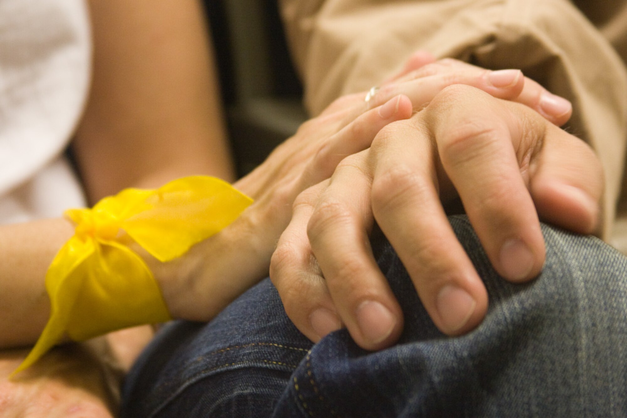 The wife of 1st Lt. Hans Jagow lays her hand on his before Lieutenant Jagow's deployment to the Horn of Africa. Thirty Airmen from the 129th Rescue Wing departed on two MC-130P Combat Shadow aircraft for a 40-day deployment to Djibouti, Africa, April 21, 2009. (Photo courtesy of Mr. Sagar Pathak, www.horizontalrain.com)