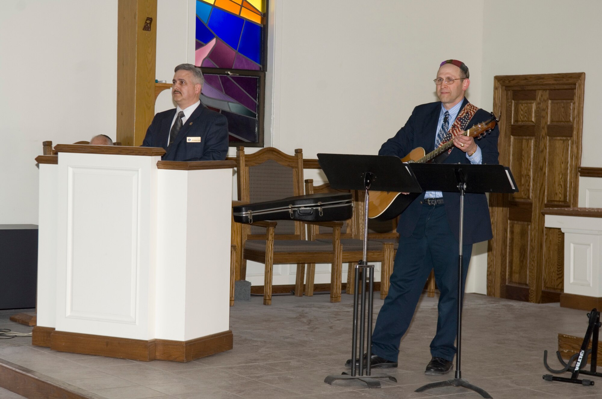 HANSCOM AIR FORCE BASE, Mass. –Stephen Klein (left), speaks during the Holocaust Remembrance event at the Base Chapel on April 28, while Howard Worona (right), Hanscom Middle School music specialist prepares to lead the musical tributes for the event. The event honored and remembered the lives of the Shtetl, the small Jewish communities of Eastern Europe, prior to and after Kristallnacht, the night of the broken glass. Kristallnacht marked the beginning of the systematic extermination of more than six million Jews. (U.S. Air Force photo by Rick Berry) 