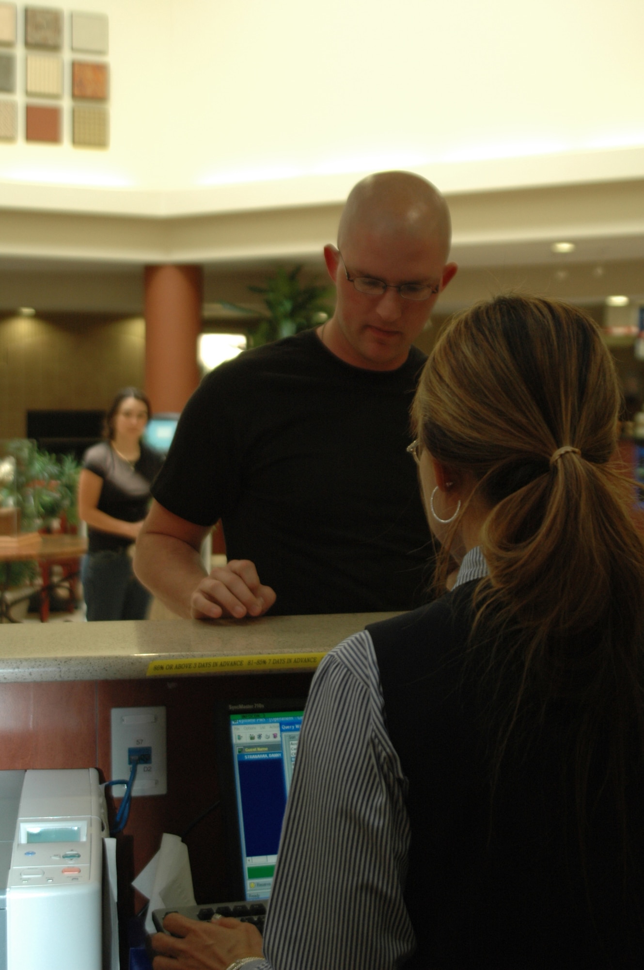 Ar left, Staff Sgt. Ryan Hinderliter stands April 27 at the front counter at the Westwind Inn at Travis as Doris Gearhart assists him. (U.S. Air Force base/Nick DeCicco)