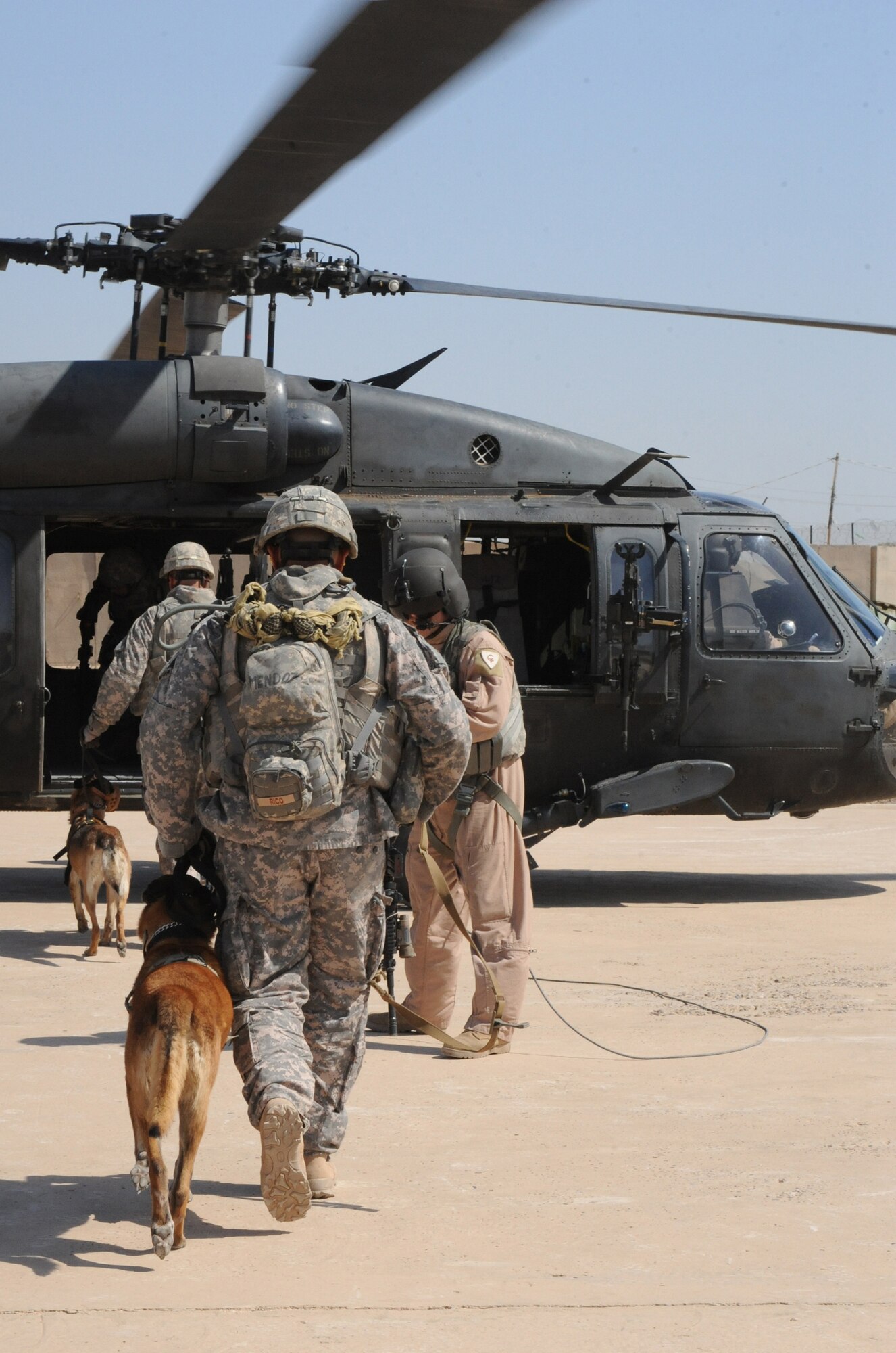 Military working dog handlers from the 332nd Security Forces Group board a helicopter with their military working dogs during training April 21 at Joint Base Balad, Iraq. The training teaches the handlers and military working dogs how to safely and properly enter and exit aircraft, and prepares them for future air-assault missions. (U.S. Air Force photo/Senior Airman Elizabeth Rissmiller) 
