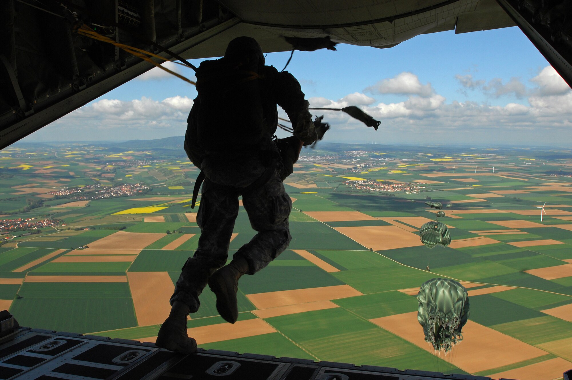 United States Air Force and Army troops jump from the tail gate of Ramsein's new C-130J Super Hercules during the first C-130J personnel drop, May 4, 2009 southern, Germany. (U.S. Air Force photo by Senior Airman Kenny Holston)