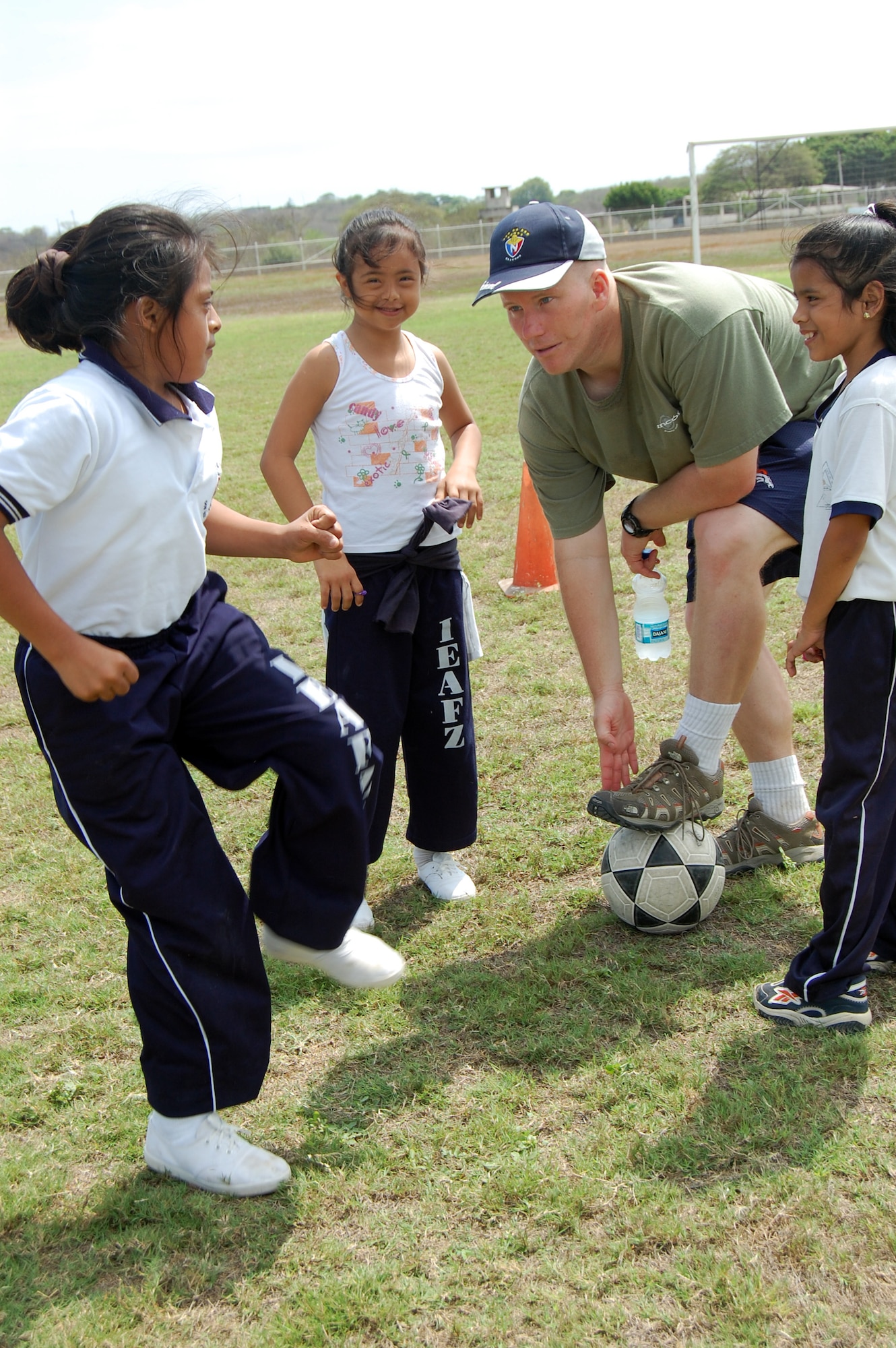 Maj. Brian Shumway, 478th Expeditionary Operations Squadron director of operations, teaches the basics of soccer to students from the Angelica Flores school at FOL Manta April 25. Volunteers from the FOL invited over 40 students to a sports day to learn American sports and build teamwork. (U.S. Air Force photo by 1st. Lt Beth Woodward)