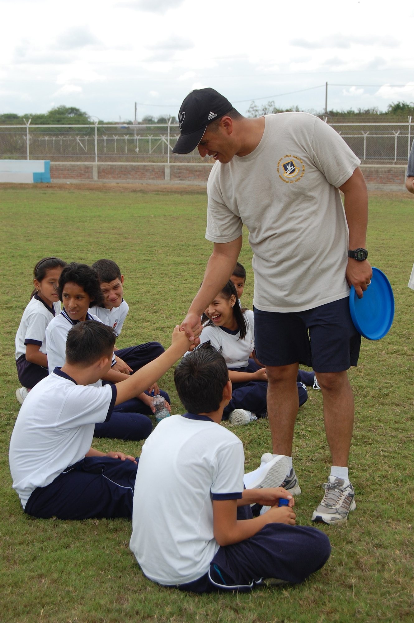 Master Sgt. Ben Miranda, 478th Expeditionary Operations Squadron chief of security forces and acting first sergeant, meets students from the Angelica Flores school at FOL Manta April 25. Volunteers from the FOL invited over 40 students to a sports day to learn American sports and build teamwork. (U.S. Air Force photo by 1st. Lt Beth Woodward)