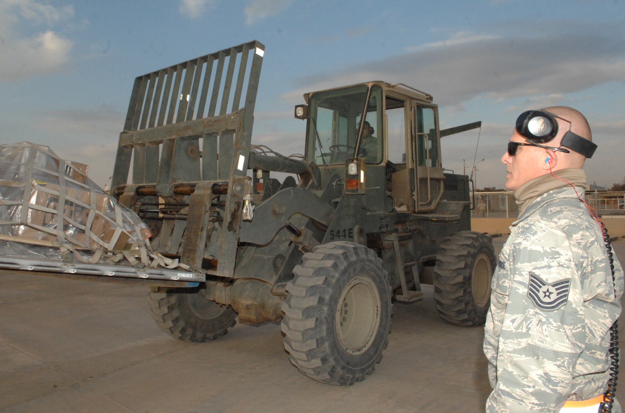 KIRKUK REGIONAL AIR BASE, Iraq -- Tech. Sgt. David Baumgartner, 506th Expeditionary Logistics Readiness Squadron, spot checks a forklift operator here in March so that pallets are properly positioned onto a 60K loader. The Tampa, Fla., native is deployed here from the 70th Aerial Port Squadron, Homestead Air Reserve Base, Fla. (U.S. Air Force photo by Senior Airman Jessica Lockoski)