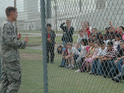 ALTUS AIR FORCE BASE, Okla. –Staff Sgt James Hall, 97th Security Forces Squadron kennel master, talks to ASPIRE, After School Program Intervention Remediation Enrichment, students of Altus about the importance of the military working dogs.  Sergeant Hall recently returned from deployment to Afghanistan with Endy, an explosive/patrol trained military working dog. While deployed Endy responded and found 3 pressure plate Improvised Explosive Devices’s and 15 caches with over 800 pounds of weapons and explosives recovered. (U.S. Air Force photo/Airman 1st Class Leandra D. Hernandez)