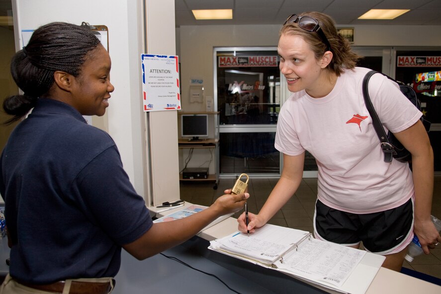 YOKOTA AIR BASE, Japan -- Airman 1st Class Brandie Taylor, 374th Force Support Squadron, hands a lock to Lindsey Wilson May 3 at Samurai Fitness Center. Customers can show their identification cards and sign out free locks for use during their workouts at the fitness center. (U.S. Air Force photo/Osakabe Yasuo)
