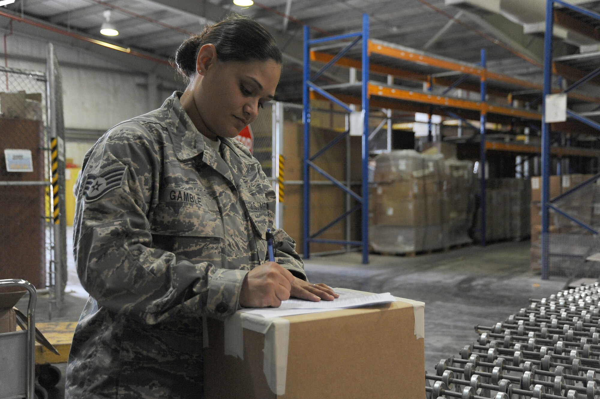 Staff Sgt. Michelle Gamble, 380th Logistics Readiness Squadron, writes down information for shipping labels, April 24 at an undisclosed location in Southwest Asia. All the supplies the base needs runs through ELRS making them a vital part of the 380th Air Expeditionary Wing's mission. Sergeant Gamble is deployed from Holloman AFB, N.M. and hails from Spring Hill, Fla. (U.S. Air Force photo by Senior Airman Brian J. Ellis) (Released)