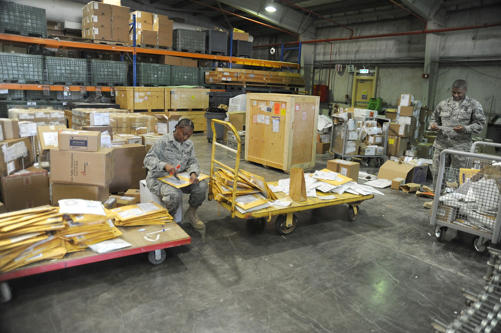 Master Sgt. Dorothy Langford and Tech Sgt. Jeremie Coleman, 380th Expeditionary Logistics Readiness Squadron, check inbound packages, April 24 at an undisclosed location in Southwest Asia. The receiving section verifies stock numbers and accounts for each item, matching it against the packing slip to ensure all items have arrived. Sergeant Langford is deployed from Spagdahlem AB, Germany and hails from Columbus, Miss. Sergeant Coleman is deployed from the Air National Guard Combat Readiness Training Center, Gulfport, Miss. and hails from Meridian, Miss. (U.S. Air Force photo by Senior Airman Brian J. Ellis) (Released)