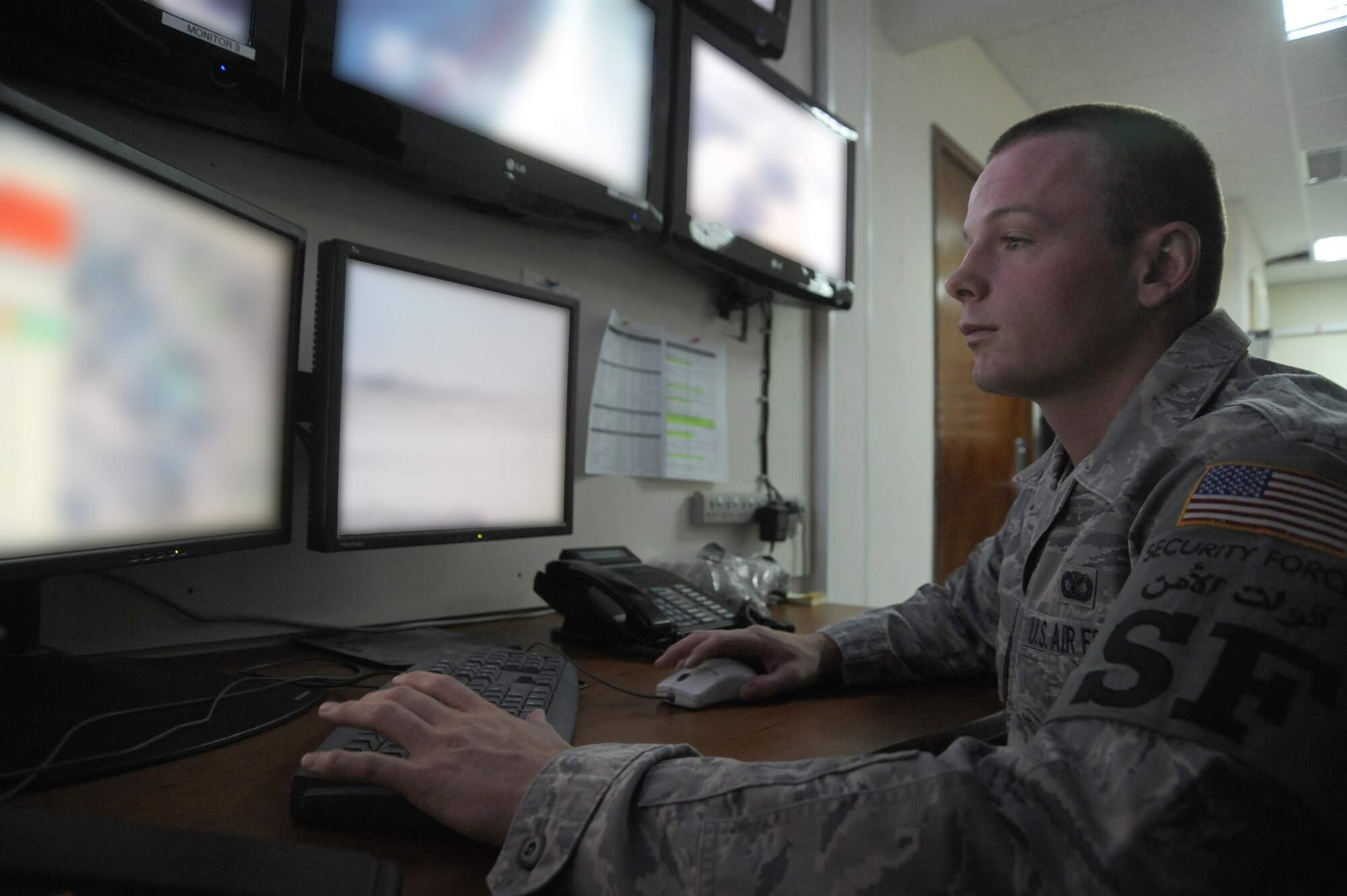 Airman 1st Class Curtis Harper, 380th Expeditionary Security Forces Squadron, security system operator monitors security camera footage in the ESFS control center, May 1 at an undisclosed location in Southwest Asia. The control center is responsible for viewing the live-feed camera footage and distributing patrols where needed. Airman Harper is deployed from Tinker AFB, Okla. and hails from Georgetown, Calif. (U.S. Air Force photo by Senior Airman Brian J. Ellis) (Released)
