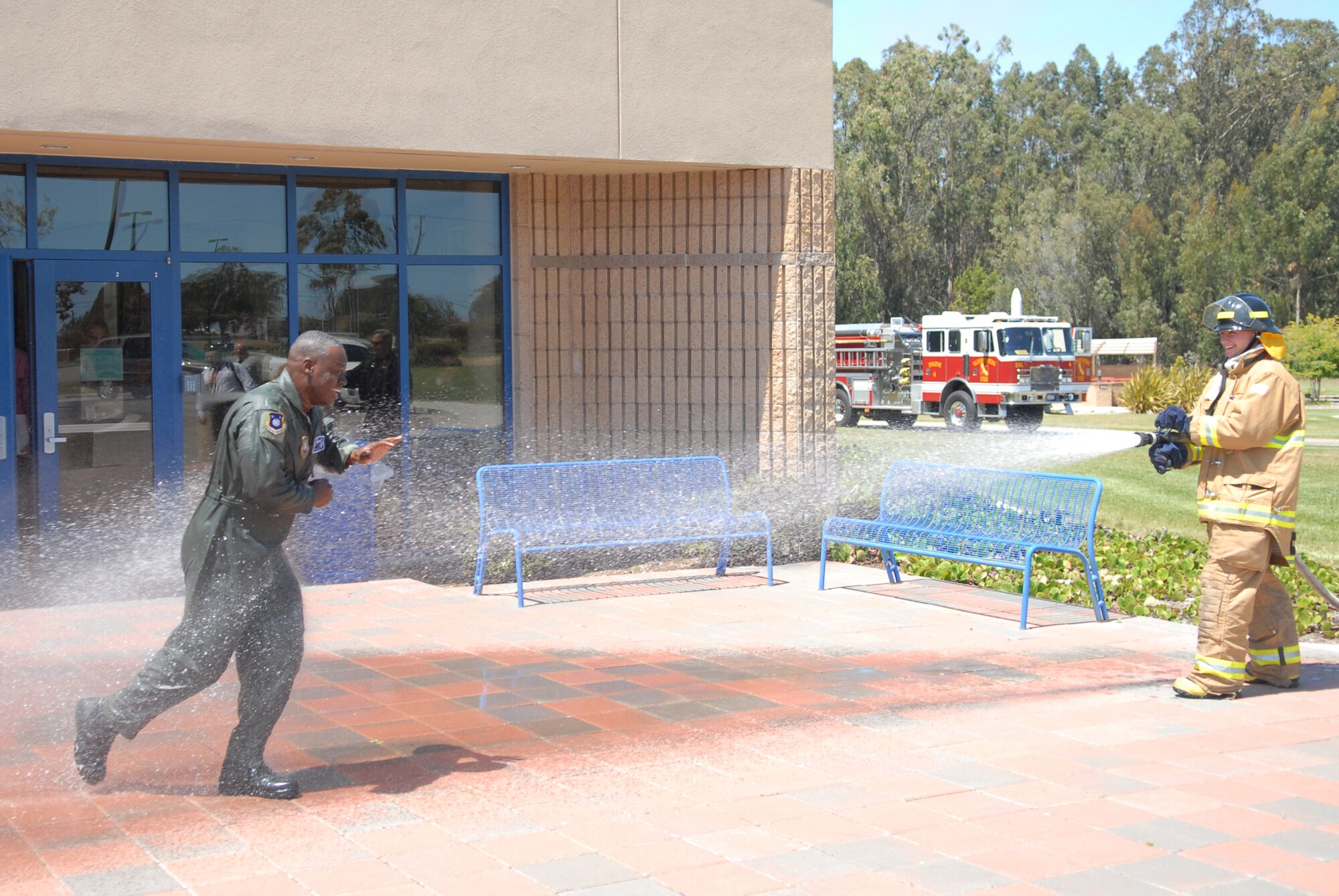 VANDENBERG AIR FORCE BASE, Calif. -- Airman 1st Class Joshua Prater, a 30th Civil Engineer Squadron firefighter, hoses down Col. Andre Lovett after he sits on console for a space launch for the last time as the 30th Operations Group commander May 5. Colonel Lovett will leave Vandenberg to become the vice wing commander of the 45th Space Wing at Patrick AFB, Fla. (U.S. Air Force photo/Senior Airman Wesley Carter)