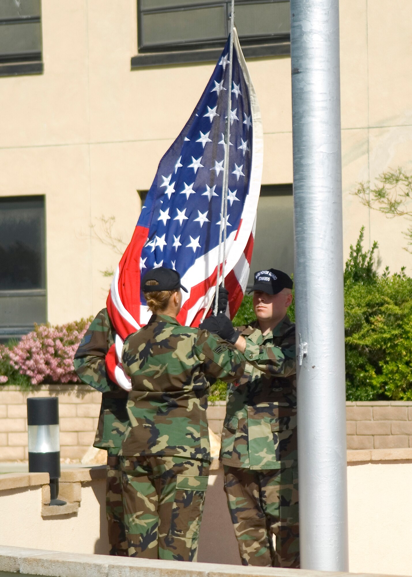 The Edwards Blue Eagle Honor Guard members lower the flag during a retreat ceremony at the Air Force Flight Test Center Headquarters April 30. The 412th Operations Group hosted the retreat ceremony. (U.S. Air Force photo/Mike Cassidy)