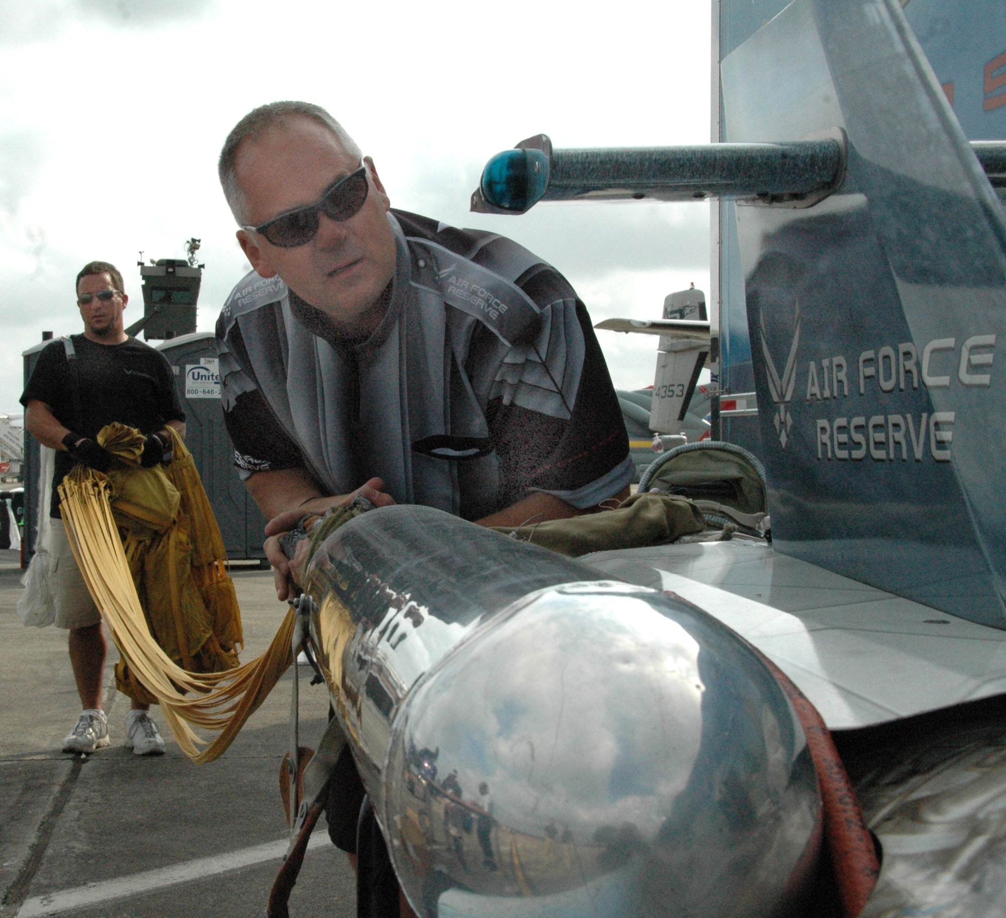 Bill Braack, retired Air Force Reservist and driver of the Air Force Reserve Jet Car, and Erik Ricketts, Braack's crew chief, prepare the jet car for the next race by packing the parachute into its storage compartment.  (U.S. Air Force photo by Tech. Sgt. Michael Duhe)