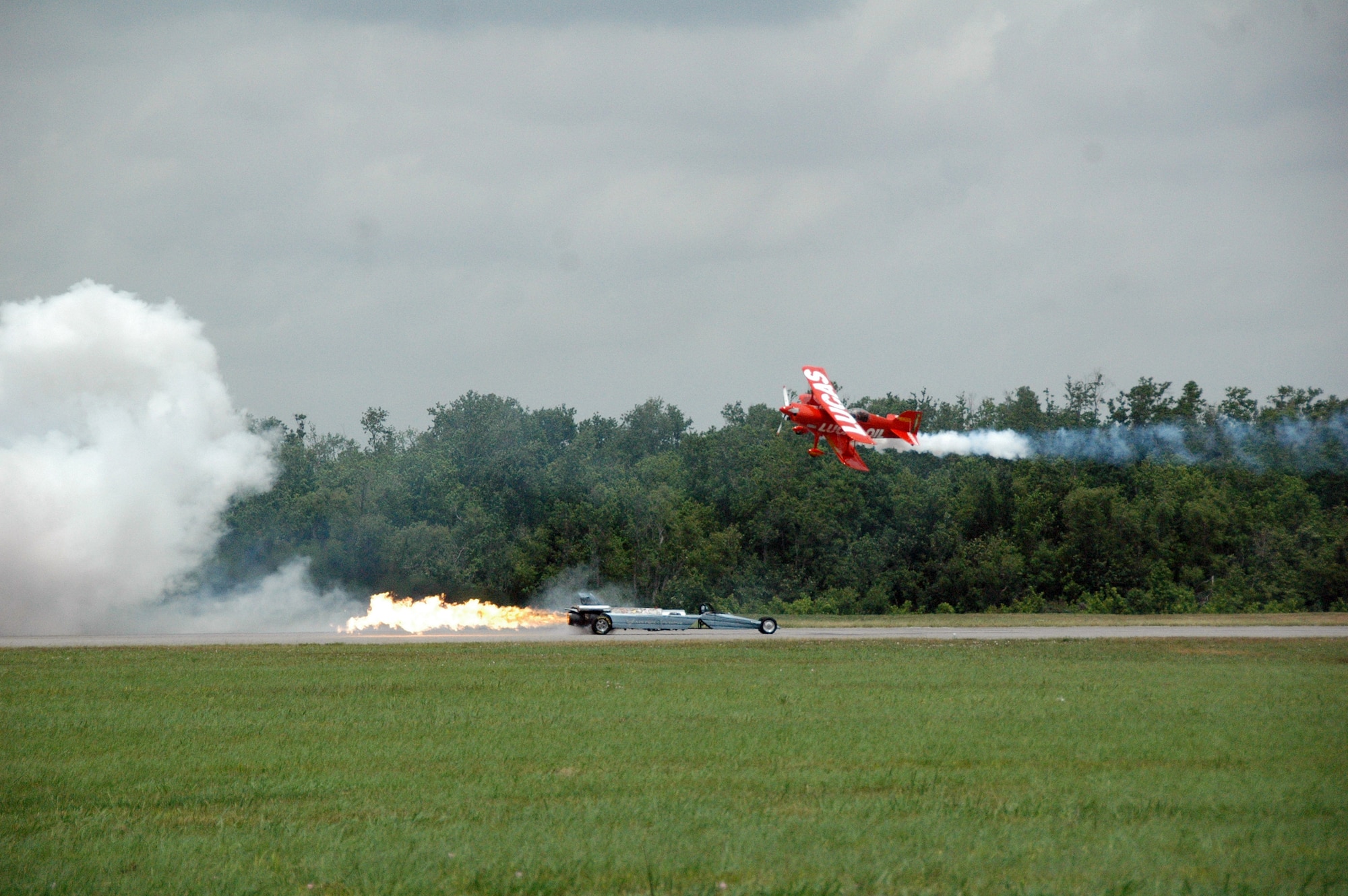 Bill Braack, retired Air Force Reservist and driver of the Air Force Reserve Jet Car, taunts Lucas Oil stunt plane pilot moments before they race on the flightline the N'Awlins Air Show held in New Orleans May 2-3.  Flying nearly 300 mph, the jet car tied with the stunt plane for a photo finish.  