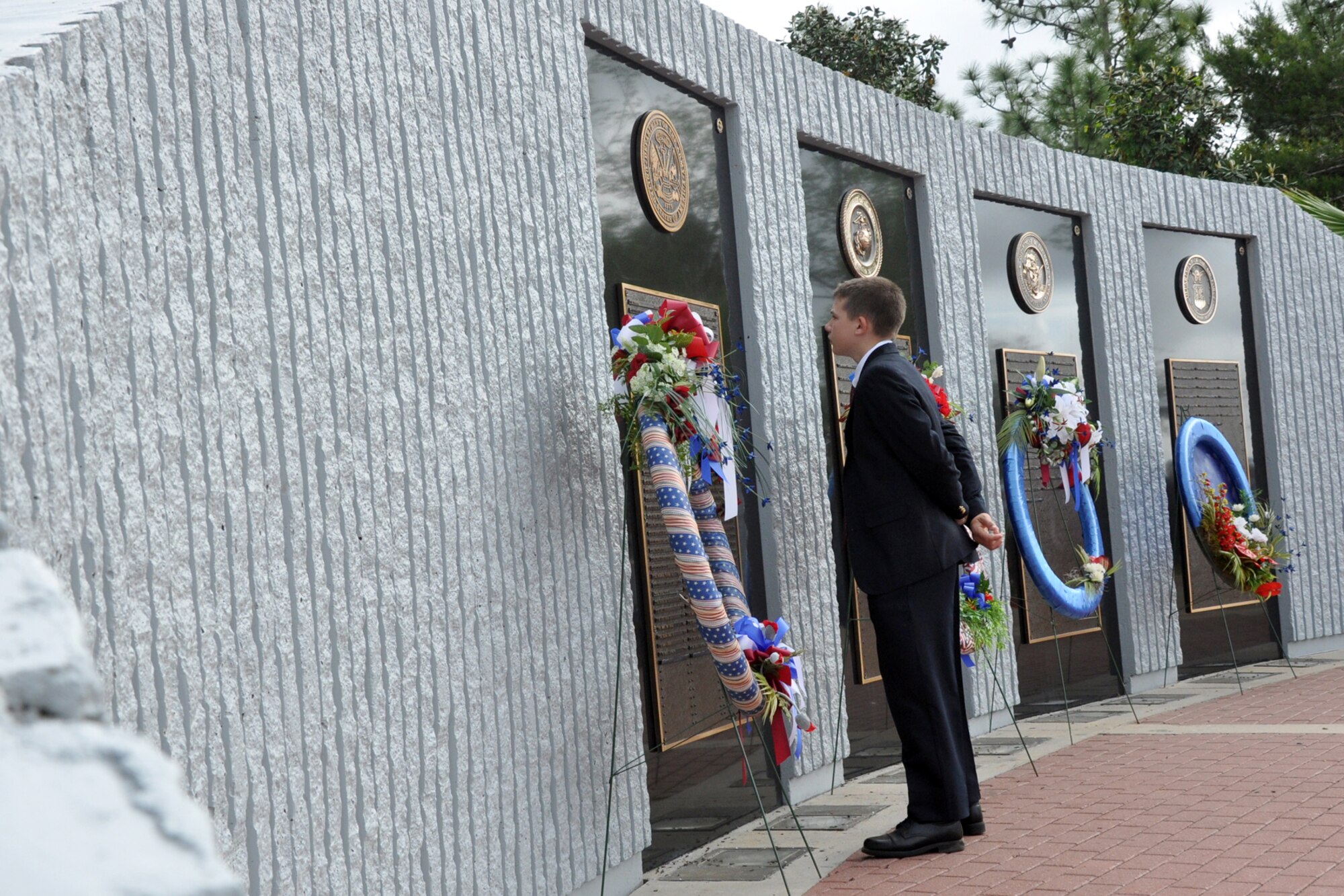 EGLIN AIR FORCE BASE, Fla. -- A boy reads names on the Explosive Ordnance Disposal memorial during the 40th Annual EOD Memorial Service May 2, at the Kauffman EOD Training Complex.  During the service, six servicemembers' names were added to the Memorial. The total now stands at 238 names. The men and women whose names are on the Memorial must be graduates of an approved EOD School who have given their lives on active duty as a result of an EOD mission since the declaration of World War II. (U.S. Air Force photo/ Airman Anthony Jennings)