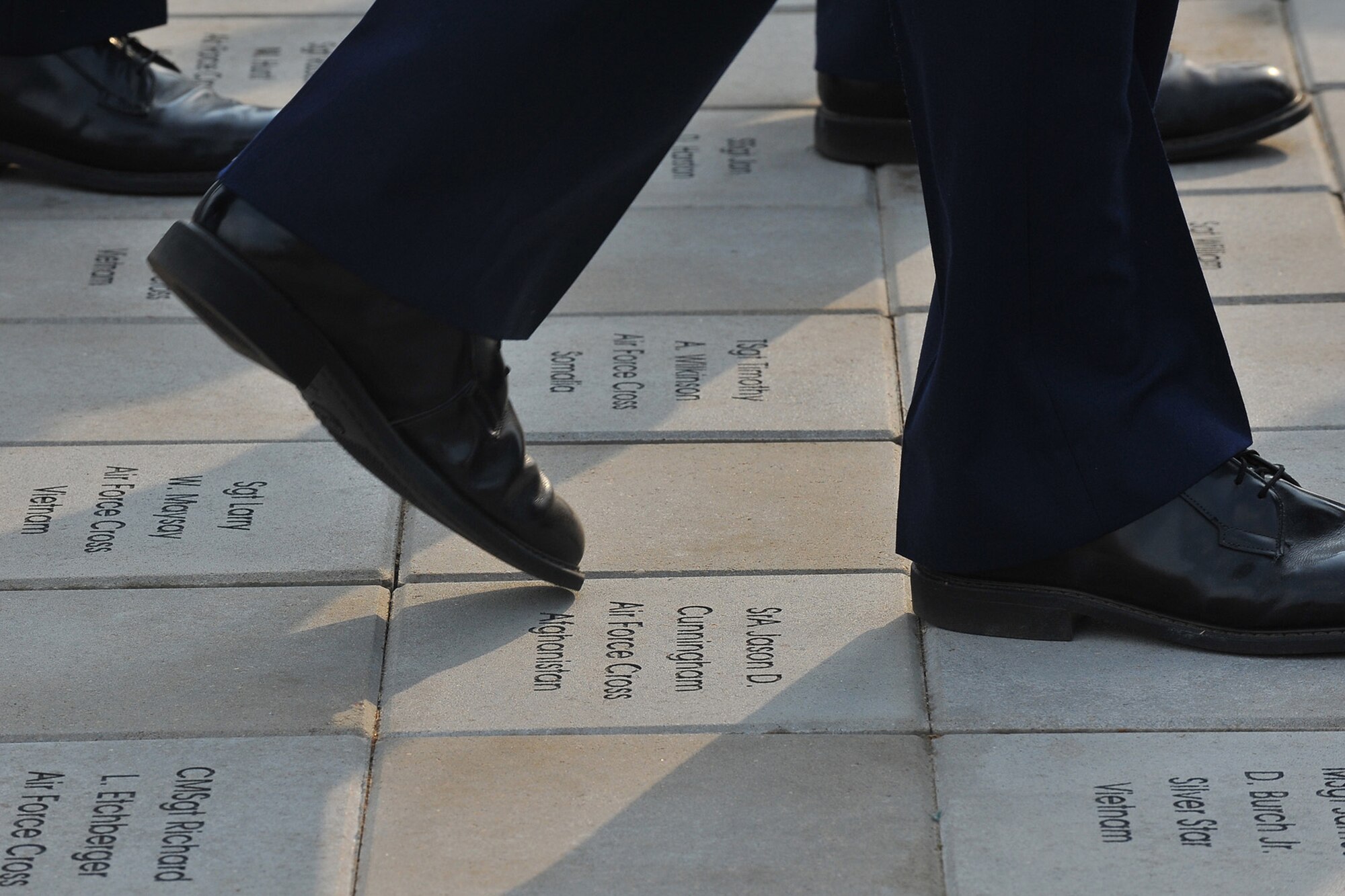 Basic trainees march on the parade grounds during their   graduation ceremony May 1 at Lackland Air Force Base, Texas. The walkway has bricks dedicated to fallen Airmen. (U.S. Air Force photo/Patrick Nugent) 