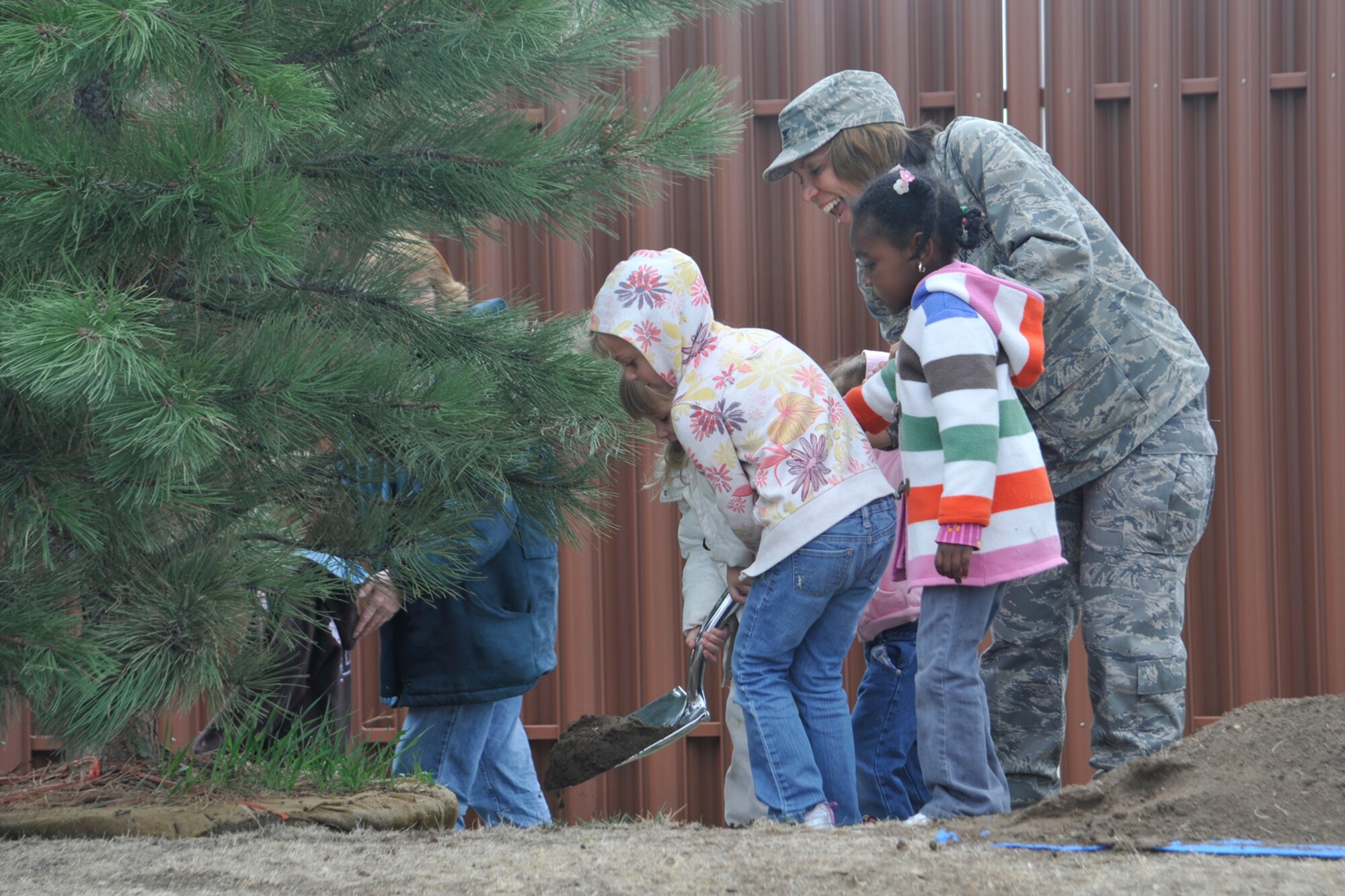 Col. Emily Buckman, 21st Mission Support Group commander, assists children enrolled in Peterson’s main base child development center plant a Ponderosa Pine at Peterson’s West Gate Visitor Center May 1. Three Ponderosa Pine trees were planted in commemoration of Arbor Day, April 24. Peterson was consecutively designated Tree City USA for the 15th year and received the eighth Tree City USA Growth Award for increasing the number and density of trees. (Air Force photo by Robb Lingley)