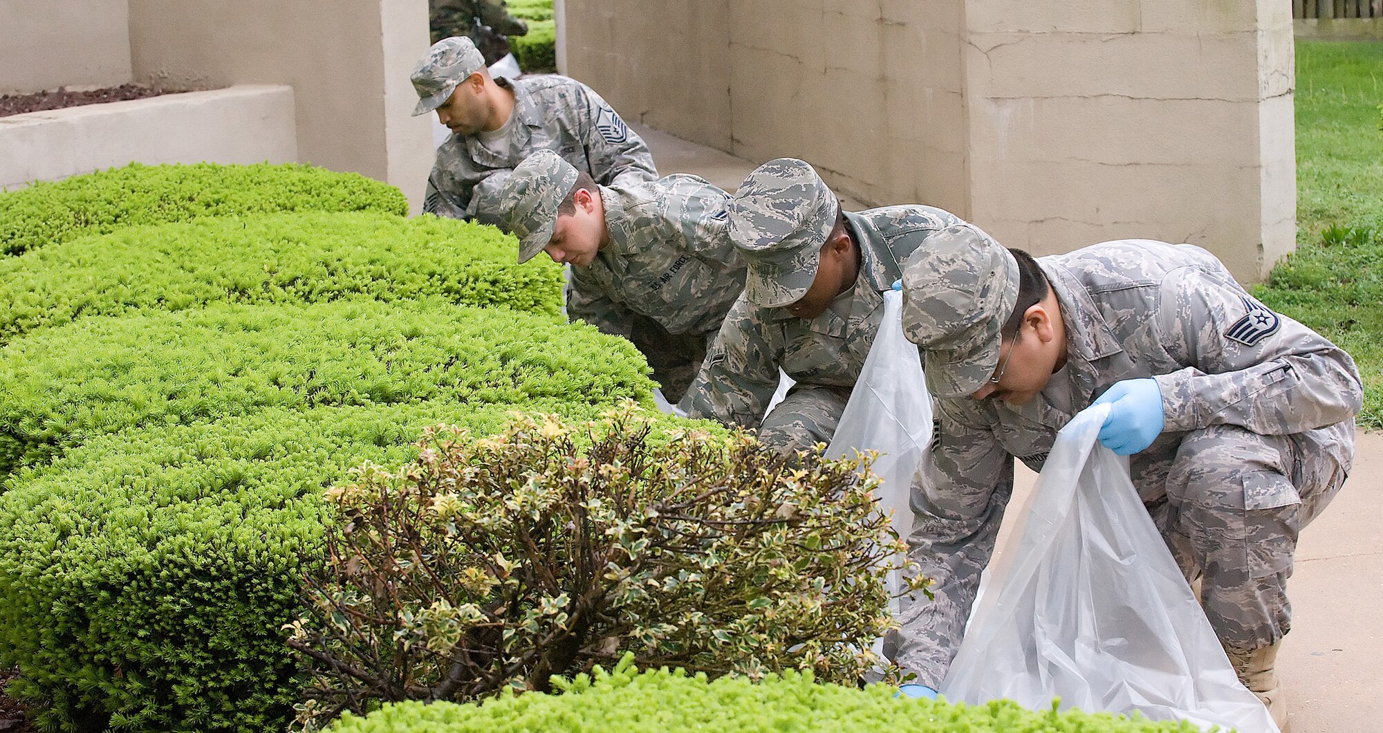 (Left to right) Master Sgt. Andre Onwawoma, Airman 1st Class Casey Robinson, Airman Robert Kelly and Staff Sgt. Jorge Fernandez from the 436th Logistics Readiness Squadron, clean up a flower bed outside Building 639. Team Dover Airmen helped to beautify Dover Air Force Base as part of Wing Clean-up Day May 5. (U.S. Air Force photo/ Jason Minto)
