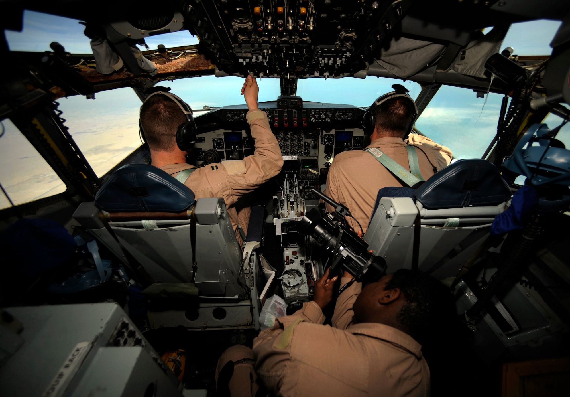 Capt. Micah Vander Veen (left) and 1st Lt. Jake Houston, assigned to the 340th Expeditionary Air Refueling Squadron at an air base in Southwest Asia, fly a KC-135 Stratotanker on an air refueling mission in support of Operation Iraqi Freedom. They are being filmed by Staff Sgt. Chalanda Roberts from the 1st Combat Camera Squadron.  (U.S. Air Force photo/Staff Sgt. James L. Harper Jr.)
