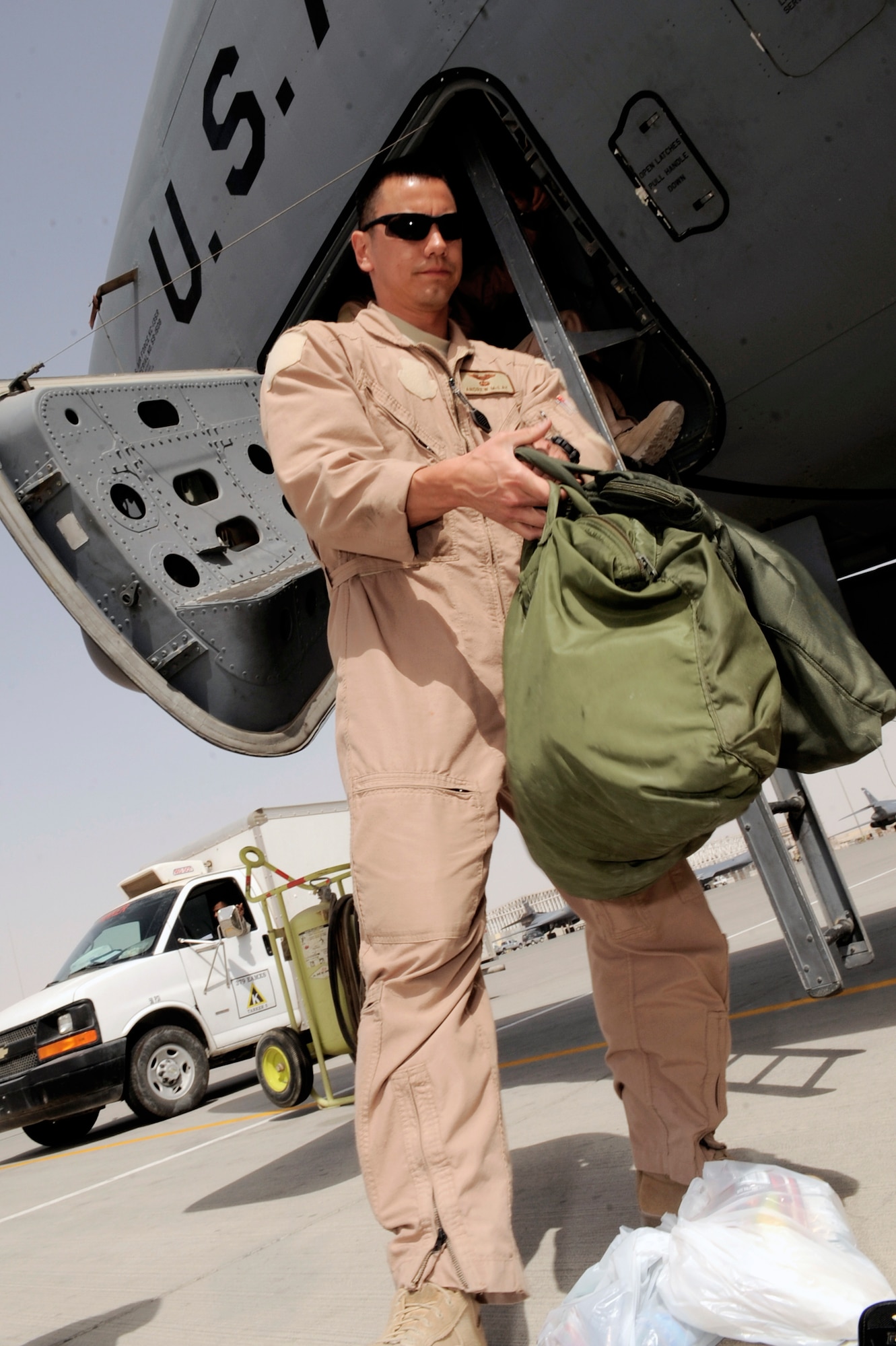 Capt. Andrew McLay, a pilot with the 340th Expeditionary Air Refueling Squadron at an air base in Southwest Asia, prepares to load his gear into a KC-135 Stratotanker before a refueling mission.  (U.S. Air Force photo/Staff Sgt. Joshua Garcia) 