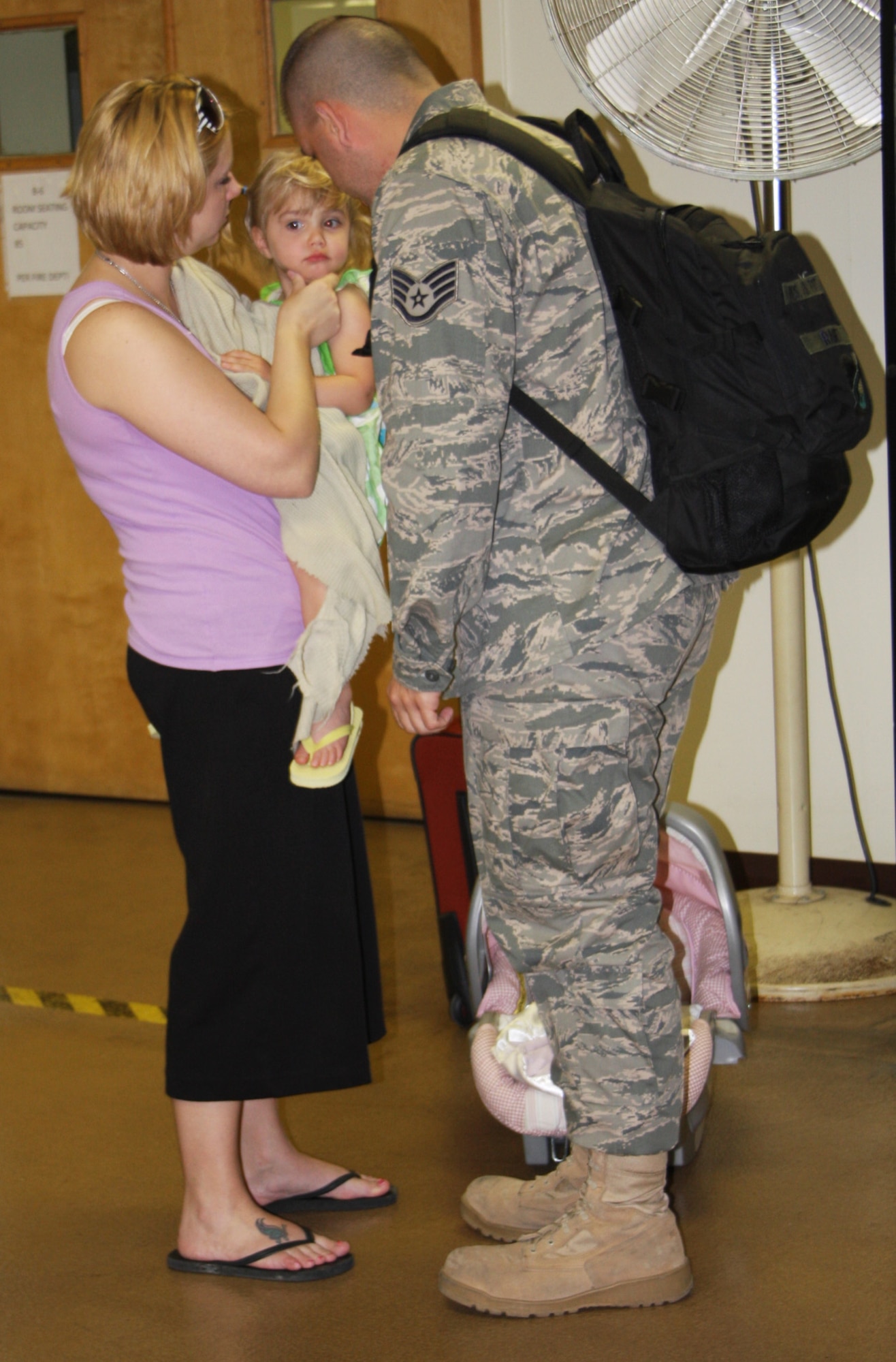 WRIGHT-PATTERSON AIR FORCE BASE, Ohio - Staff Sgt. Chad Ramey, 87th Aerial Port Squadron, kisses his daughter, Randee, good bye as his wife, Charlee, looks on.  Sergeant Ramey departed on April 24th with fellow reservists from his squadron on a deployment to the AOR. Twenty-three members of the 87th APS departed in April and another 33 are scheduled to leave in stages throughout May. The reservists are deploying for a four-month rotation as the lead APS for an air base in the region with additional members joining them from various units throughout the United States. (Air Force photo/Stacy Vaughn)