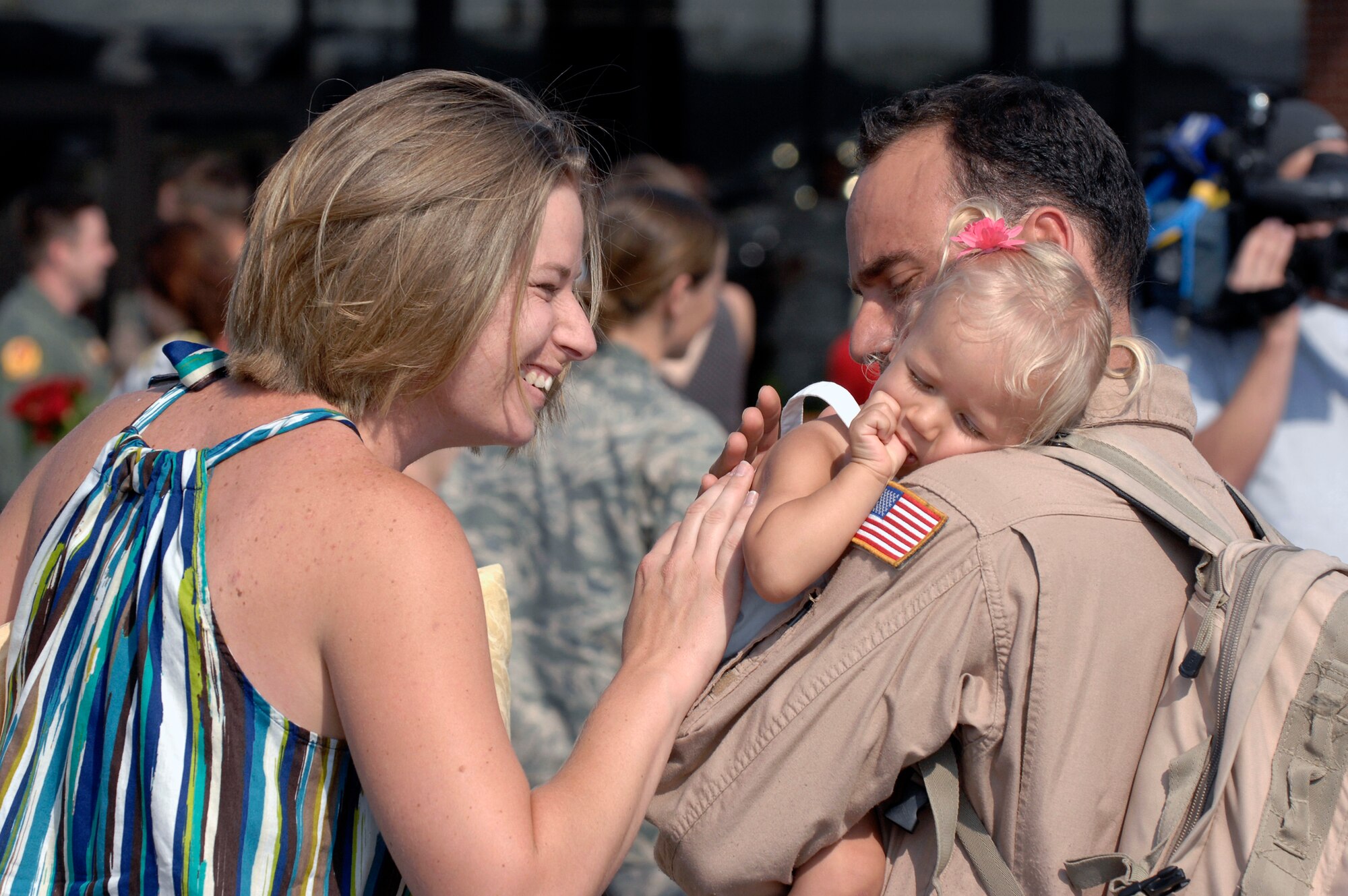 Tech. Sgt. Augie Nalsen reunites with wife, Christina, and daughter, Cali, May 3 at Charleston Air Force Base, S.C. More than 140 Airmen from the 16th Airlift Squadron returned from their 120-day deployment to the Middle East supporting operations Enduring Freedom and Iraqi Freedom and operations in the Horn of Africa. While deployed, the 16th AS executed 142 airdrops that resupplied servicemembers serving in the regions with 3.7 million pounds of supplies. Sergeant Nalsen is a loadmaster for the 16th AS. (U.S. Air Force photo/James M. Bowman)
