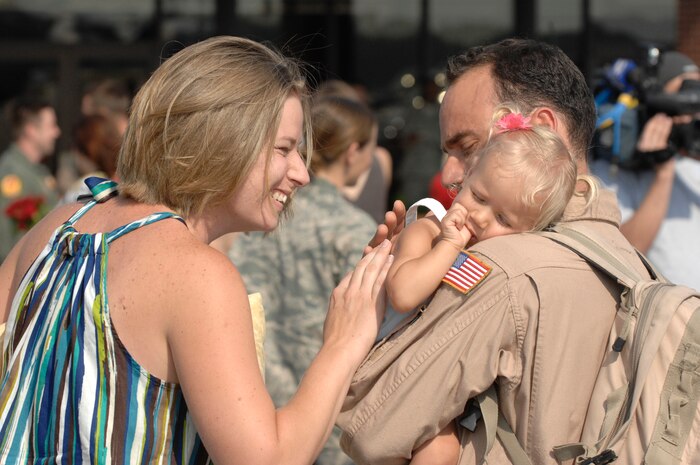 U.S. Air Force Tech. Sgt. Augie Nalsen reunites with wife, Christina, and daughter, Cali, at Charleston Air Force Base, S.C., May 3, 2009.  More than 140 Airmen from the 16th Airlift Squadron returned from their 120-day deployment to the Middle East supporting Operations Enduring and Iraqi freedom and operations in the Horn of Africa. While deployed, the 16 AS executed 142 airdrops, more than any of its predecessors, which resupplied service members serving in the regions with 3.7 million pounds of supplies. Sergeant Nalsen is a loadmaster for the 16 AS. (U.S. Air Force photo by James M. Bowman)(Released)