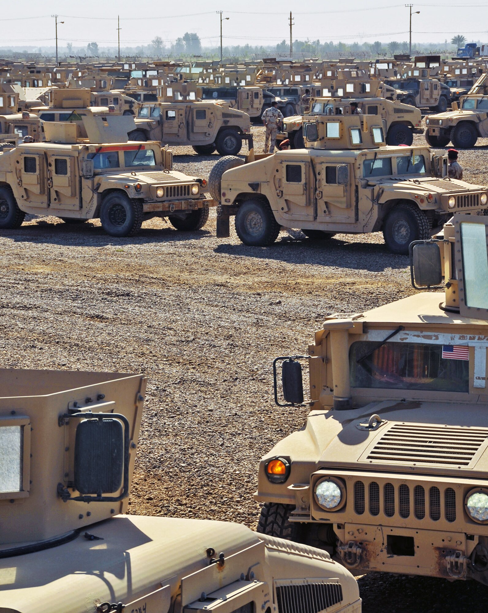 U.S. and Iraqi army soldiers drive M1114 Humvees to the Iraqi-run section of the camp for processing in March at Camp Taji, Iraq. The soldiers work with the Taji Redistribution Property Assistance Team to process M1114 up-armored Humvees that will be sold to the Iraqi government. The Humveess will later be distributed to Iraqi army and police for use during day-to-day operations. (U.S. Air Force photo/Staff Sgt. Dilia Ayala) 
