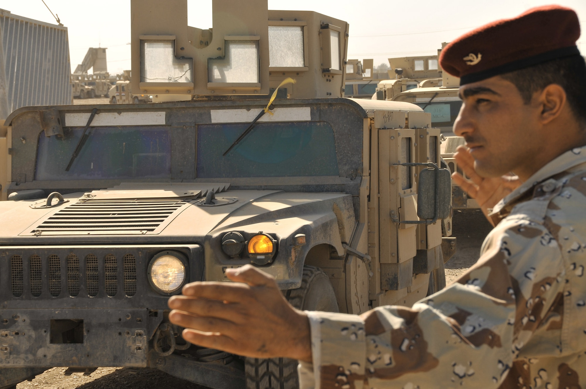 An Iraqi army private directs U.S. and Iraqi soldiers as they drive M1114 Humvees from the Taji Redistribution Property Assistance Team Humvee yard to the next staging point in March at Camp Taji, Iraq. The RPAT works with Multinational Security Transition Command-Iraq officials to turn over up-armored Humvees that will be sold to the Iraqi government for use by the Iraqi army and police. (U.S. Air Force photo/Staff Sgt. Dilia Ayala) 
