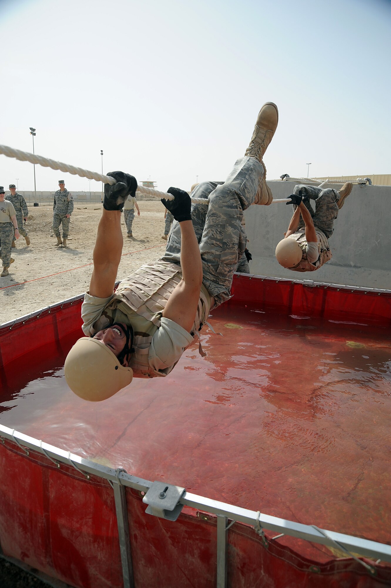 Senior Airman Matthew McCarthy uses a 15 foot rope to cross a water obstacle with his teammates following during a Defender Challenge course April 25 at an air base in Southwest Asia. His team won the competition beating out the second place team by one second. Airman McCarthy is assigned to the 380th Expeditionary Civil Engineer Squadron and deployed from Bolling Air Force Base, D.C. He hails from Omaha, Neb. (U.S. Air Force photo/Senior Airman Brian J. Ellis)