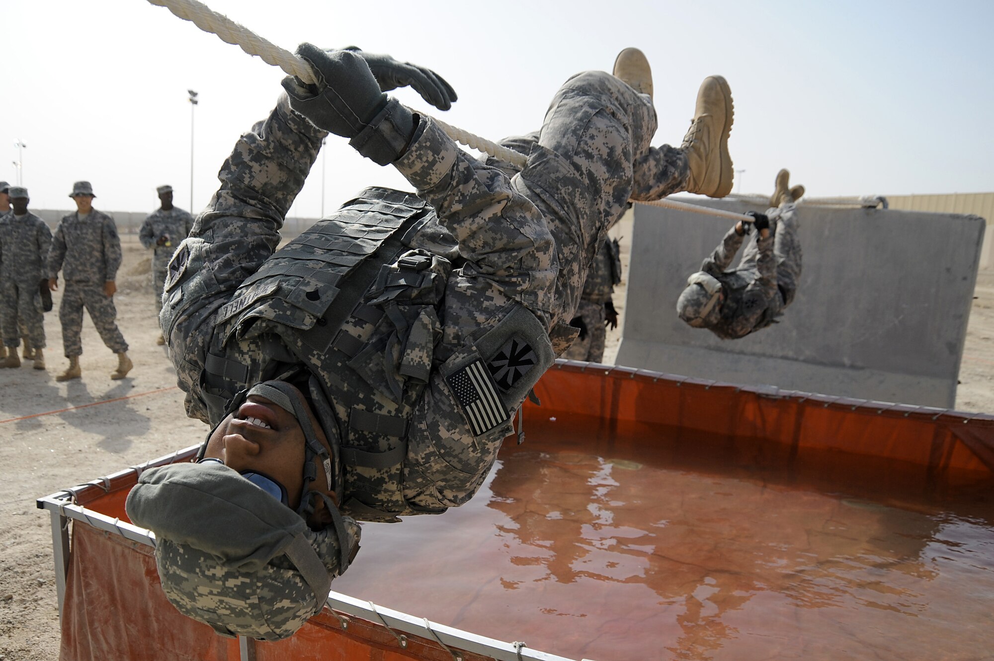 Army Spc. Alexandre Whitnell uses a 15 foot rope to cross a water obstacle with his teammates following behind during a Defender Challenge course April 25 at an air base in Southwest Asia. Specialist Whitnell is with the 5-52 Air Defense Artillery Battalion out of Fort Bliss, Texas. The competition was close with his team finishing second place, just one second behind the winning team. (U.S. Air Force photo/Senior Airman Brian J. Ellis)