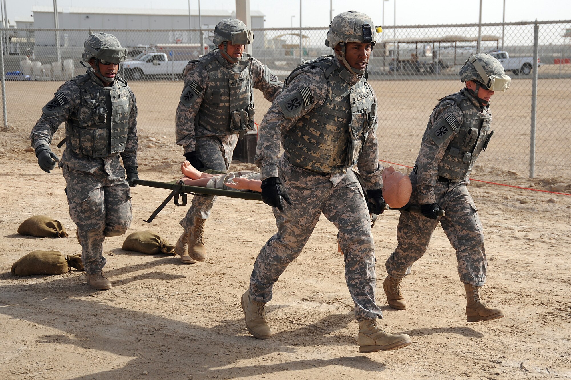 Army Spc. Alexandre Whitnell, Army Staff Sgt. Patrick Gonzales, Army 1st Sgt. David Foulkes and Army Spc. Jennifer Stecher carry a "body" on a stretcher during a Defender Challenge course April 25 at an air base in Southwest Asia. The 5-52 Air Defense Artillery Battalion team finished in second place, just one second behind the winning team. All four Soldiers are deployed from Fort Bliss, Texas. (U.S. Air Force photo/Senior Airman Brian J. Ellis) 