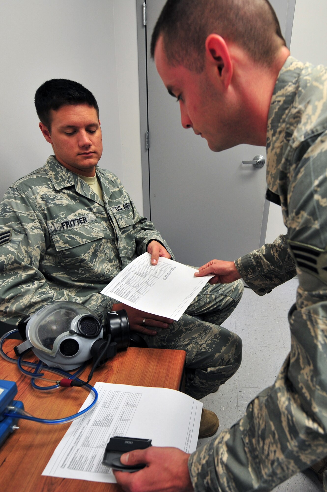 Shaw Air Force Base, S.C.- Senior Airman William Fritter receives his gas mask fit test from Senior Airman Earl Barnes, both Airman are bioenvironmental journeyman from the Bioenvironmental Squadron, after completing his quantitative fit test, May 1, 2009.  This will be the only QNFT SrA Fritter will need according to AFI 48-137; unless a new type of mask is issued, 10 percent of body weight is lost or gained, or extensive dental or facial surgery is performed.  (U.S. Air Force Photo by Senior Airman William Coleman)